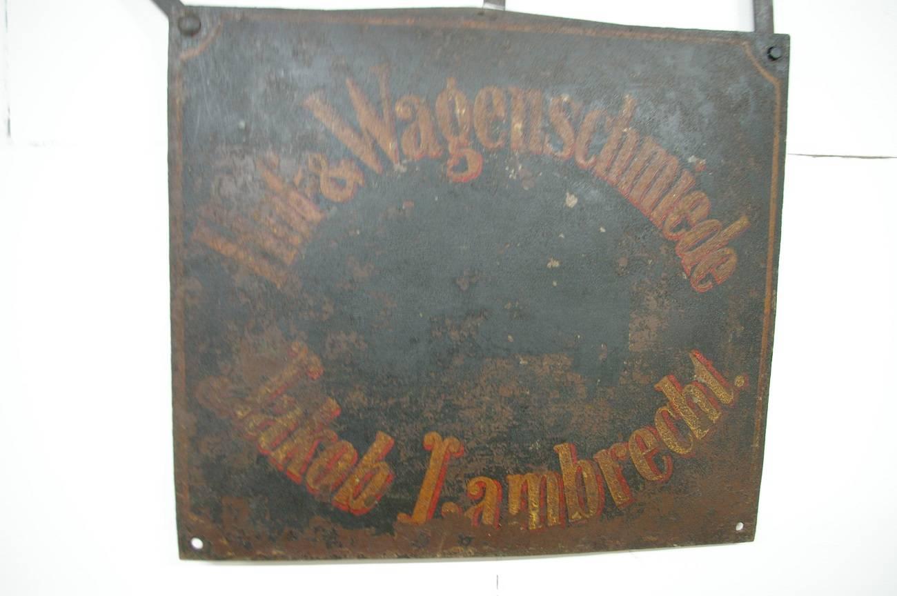 A super awesome antique signboard of a blacksmith with the text 