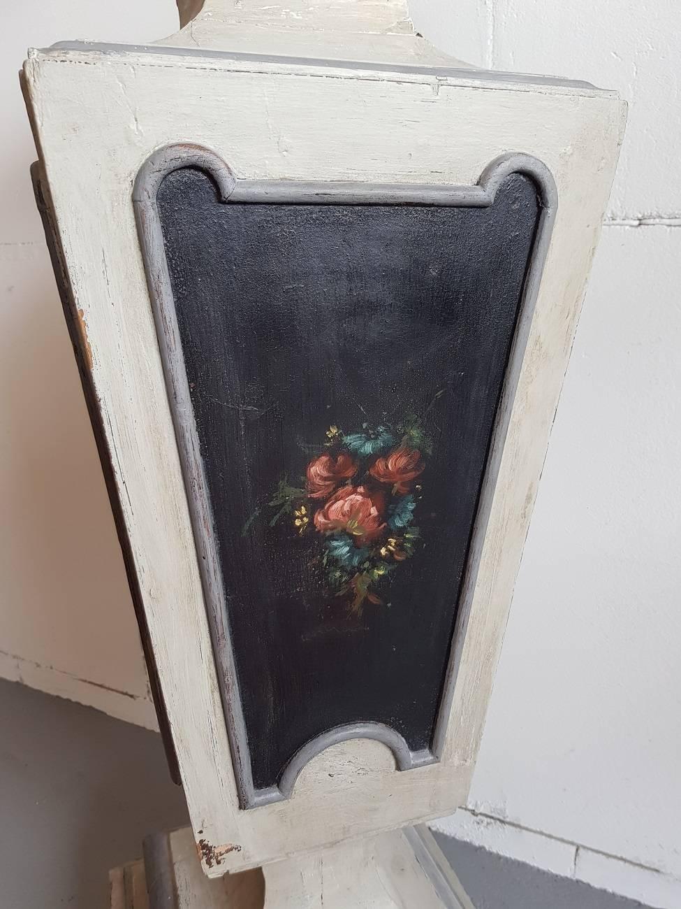 Early 19th century French painted wooden column, it's painted in the colors grey and white with on all panels around a painted floral decor on black background.
It has a lovely distressed patina all around.

The measurements are,
Depth 33 cm/
