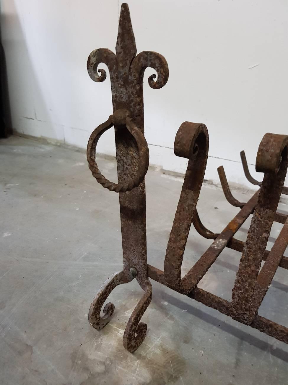 French vintage wrought iron fireplace grate/basket with ornaments in the shape of the French Lily, it's made, circa 1960-1970 and has some rust all around but not damaged or cracked.

The measurements are:
Depth 66 cm/ 25.9 inch.
Width 83 cm/