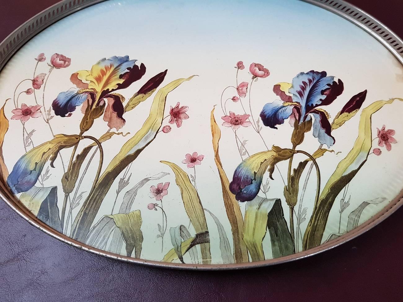 Beautiful Art Nouveau serving tray with nickel-plated frame and porcelain bottom with floral decor from, circa 1910. One handle is restored at the bottom.

The measurements are:
Depth 30 cm/ 11.8 inch.
Width 48.5 cm/ 19 inch.
Height 4.5 cm/ 1.7