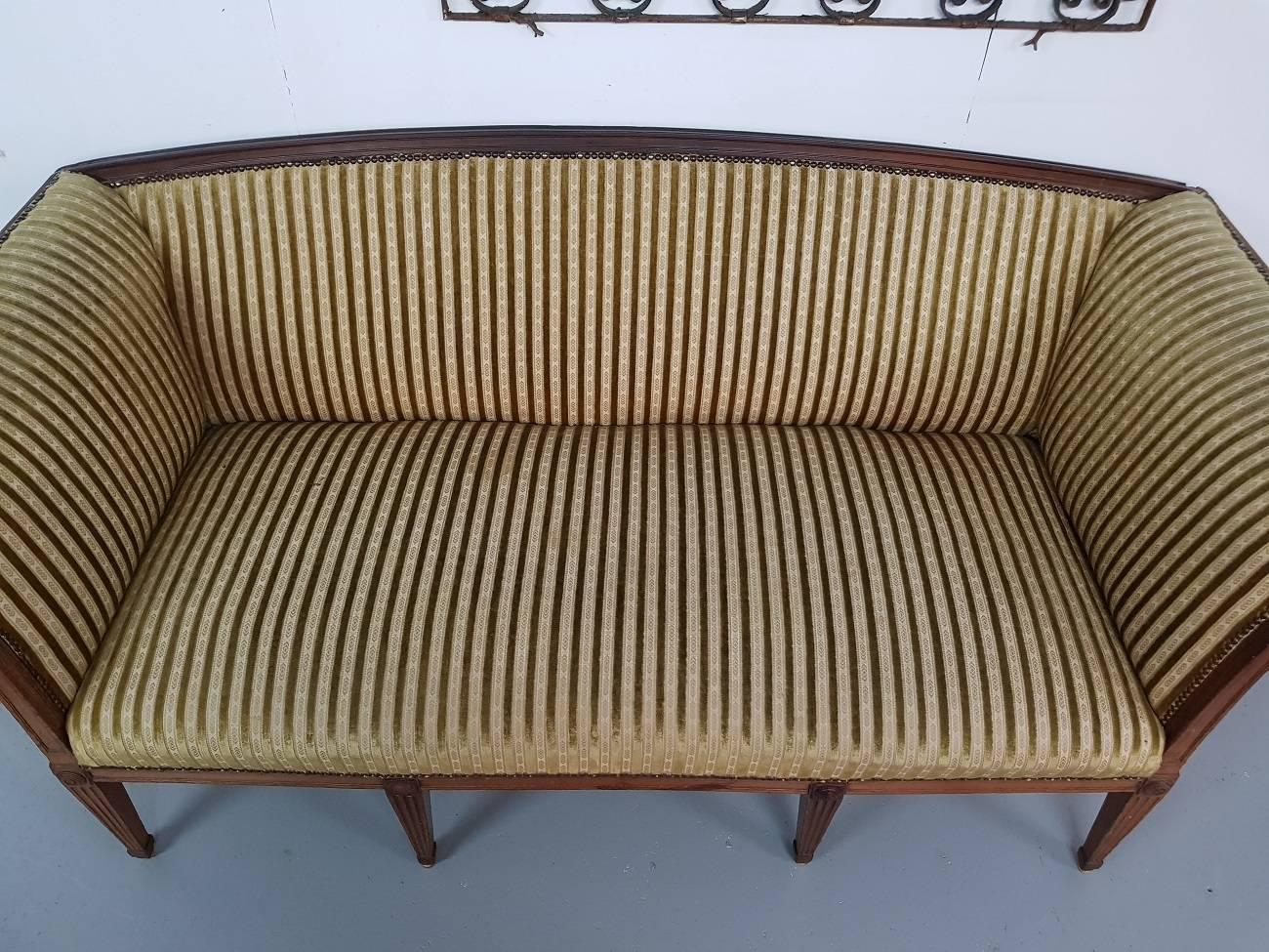 French antique 19th century mahogany wooden Louis XVI style sofa with striped velvet upholstery from the 1950s. It has some old restorations around and need some attention but when refinished a lovely piece.

The measurements are,
Depth 75 cm/