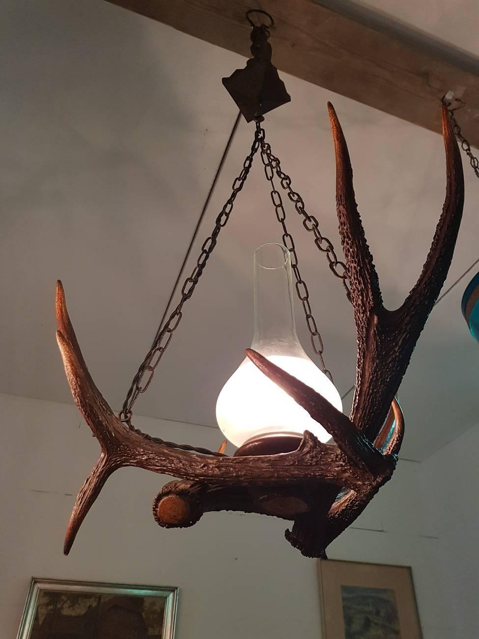 Vintage antlers chandelier from circa 1960-1970 made of three real antlers with beautiful partly frosted glass oil lamp glass. The electricity has been renewed with black braided electric cable including fitting.

The measurements are,
Depth 55