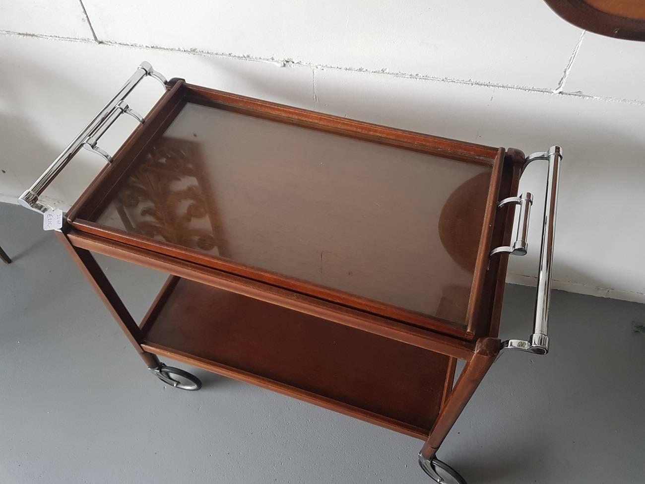 French Vintage serving table from the 1960’s with chrome handles and portable tray with glass bottom. In a good condition with some scratches on the glass and wear consistent with age and use.

The measurements are,
Depth 42,5 cm/ 16.7 inch.
Width