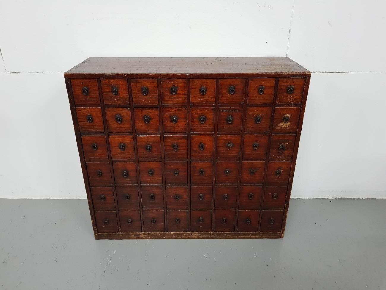 Antique late 19th century Japanese softwood pharmacists cabinet with 48 drawers with text on the back and on the side of the drawers it's sold by Luc Ritter Brussel in 1993 (it has old traces of woodworm but has been treated).

The measurements