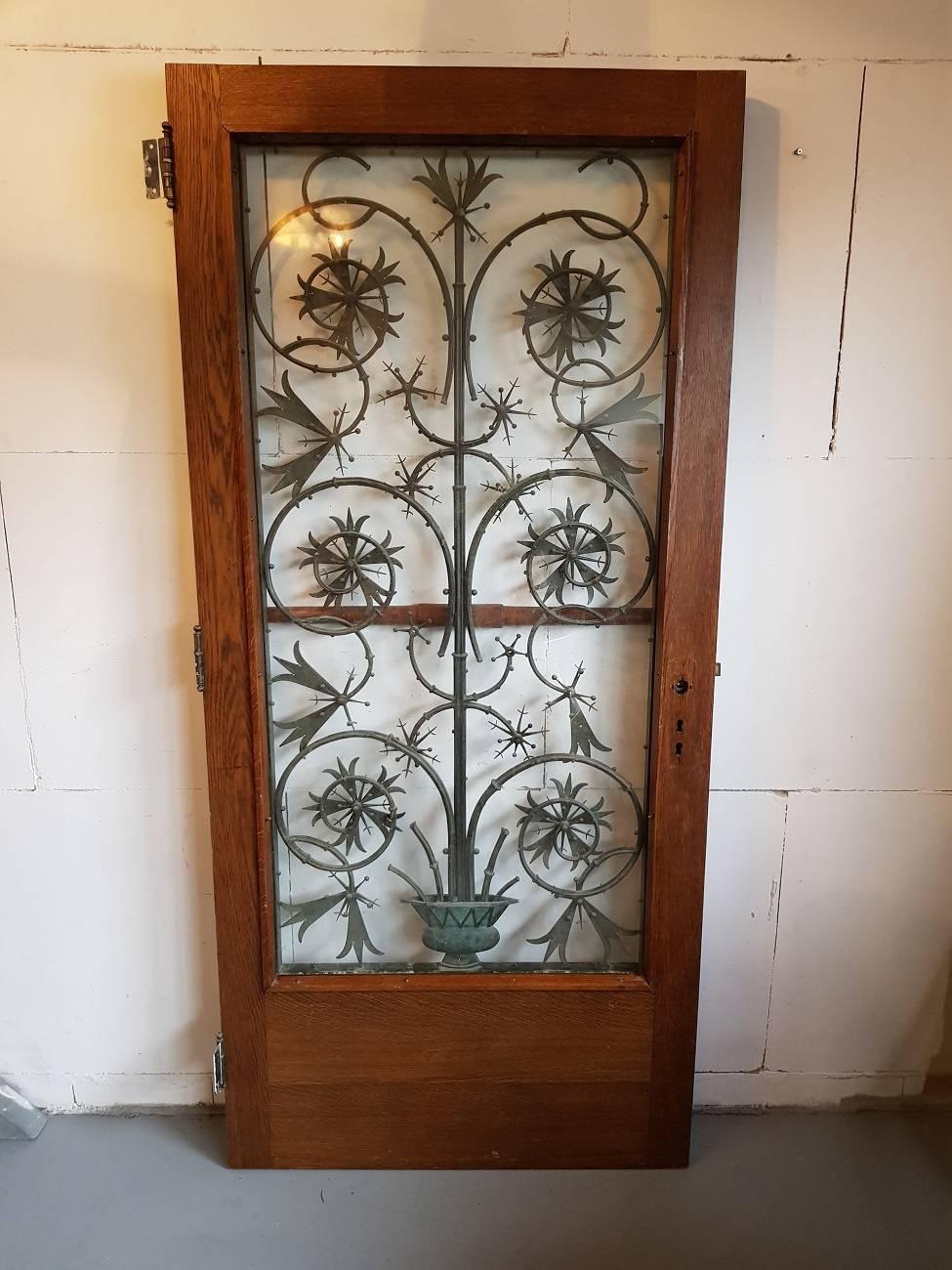 Handmade bronze Art Nouveau door grille mounted in a solid oak door from about 1910. The grille can be sold with out the door.

The measurements including the door are, 
Depth 4,5 cm/ 1.7 inch.  The bronze grille alone is Depth 3,5 cm/ 1.3