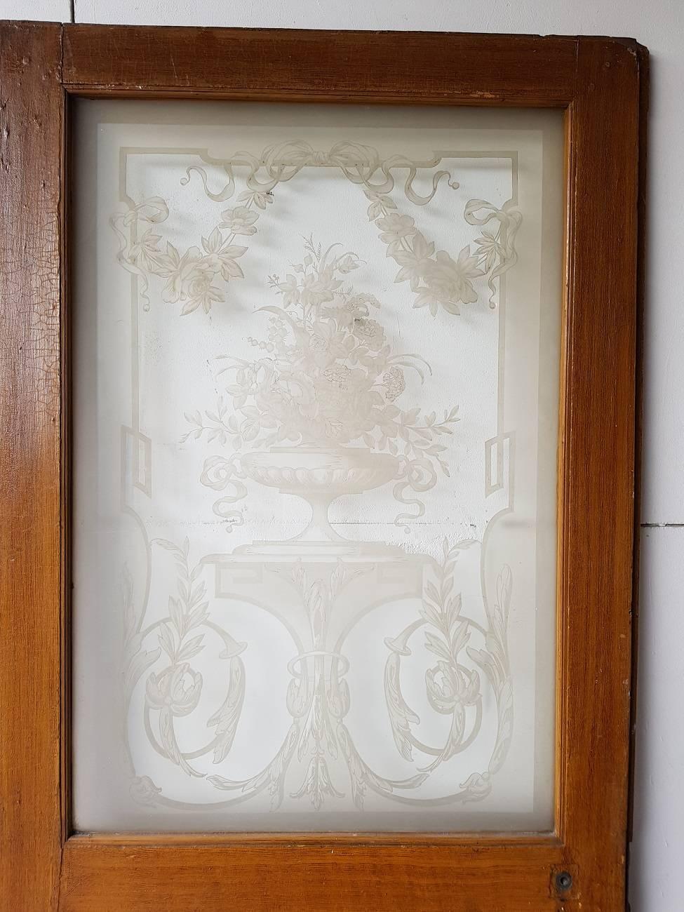 Old Dutch wooden door from the late 19th century with painted wood design and stunning etched glass panel depicting flowers in a vase standing on a console and around richly decorated with garlands and curls.

The measurements are,
Depth 3 cm/