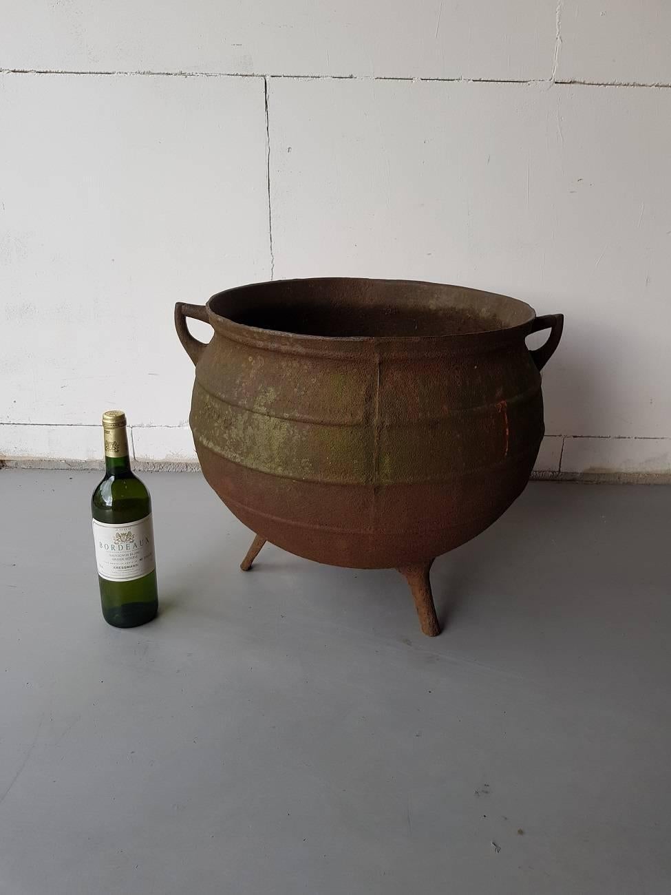 Old and large cast iron witches cauldron or kettle with two ears and standing on three legs and is made circa 1900 with the founders name but unclear.

The measurements are:
Depth 45 cm/ 17.7 inch.
Width 45 cm/ 17.7 inch.
Height 43 cm/ 16.9