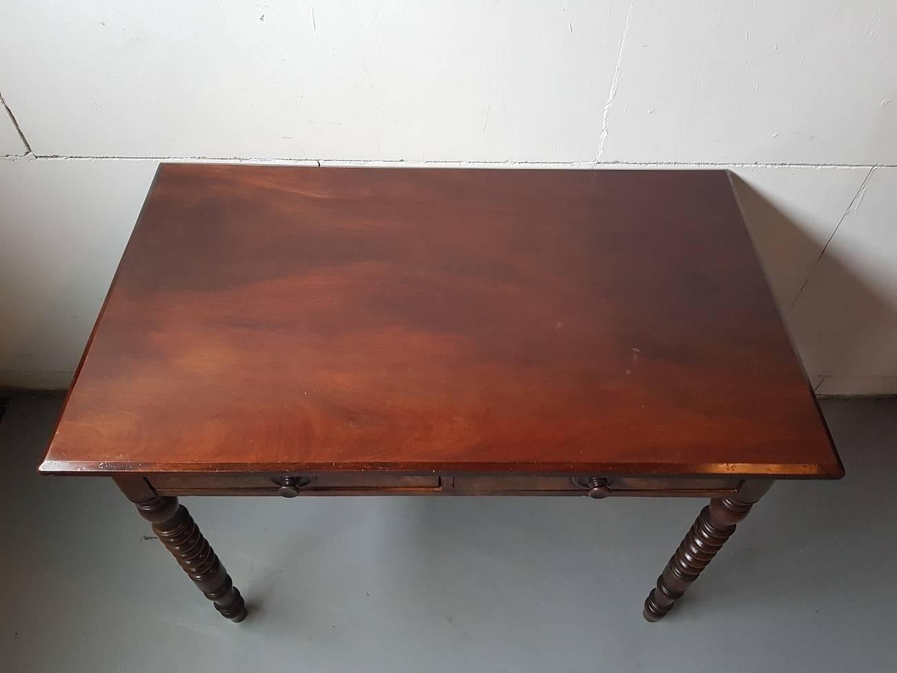 Dutch Antique partly solid and veneered mahogany table, circa 1880 with two drawers and standing on turned legs with various shapes.

The measurements are,
Depth 65 cm/ 25.5 inch.
Width 100 cm/ 39.3 inch.
Height 75 cm/ 29.5 inch.
    