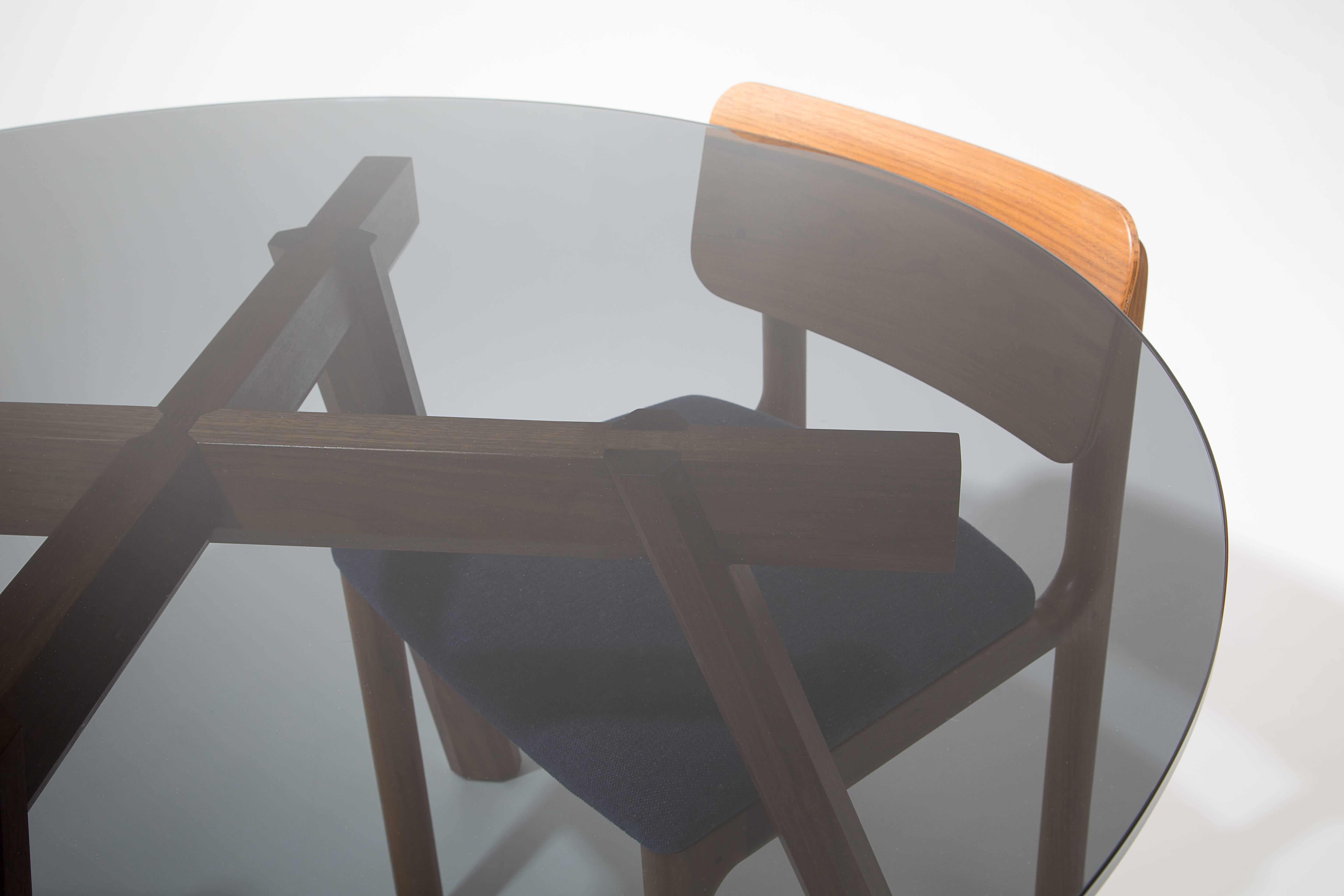 Der Ripley-Esstisch wird in unserem Studio in Louisville, KY, von Hand aus hochwertigen Harthölzern gefertigt. Der Sockel ist mit traditionellen Tischlerarbeiten konstruiert, und diese Tischlerarbeiten sind durch die Glasplatte zu sehen. Die