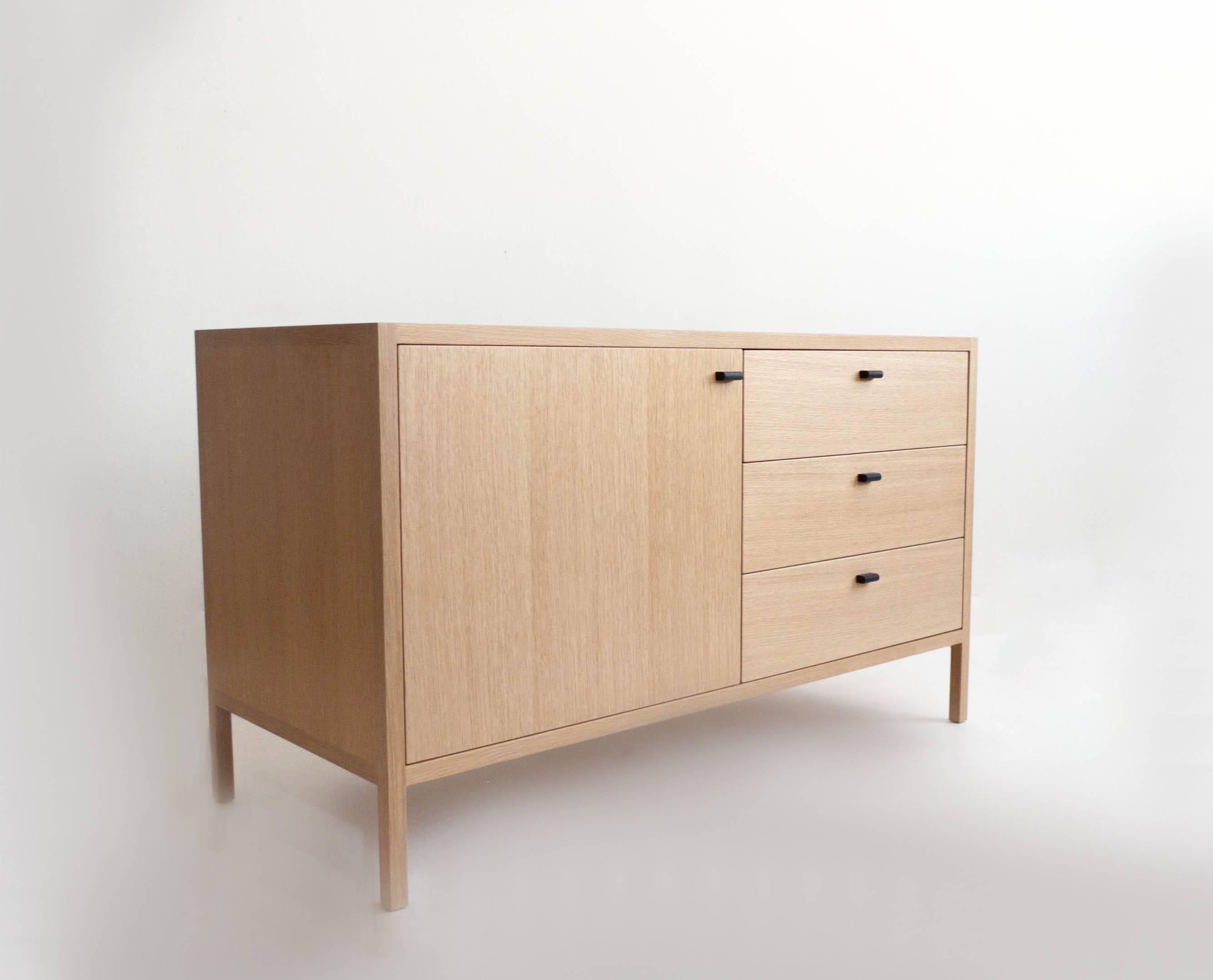 The Laska credenza is built in our Louisville, KY studio using premium hardwoods and thoughtfully selected wood veneers. This piece features custom veneered panels framed flush with solid hardwood edges and legs. The three solid wood drawers ride on