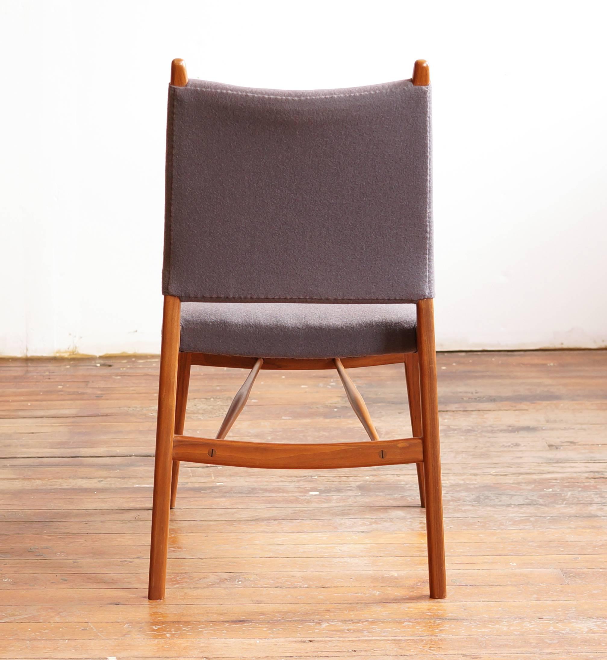 The C05 dining chair in solid walnut, with upholstered seat and back. Two lower spindles add strength and a decorative element with exposed wedged joinery. This chair nods to midcentury classics in the subtle interplay between wood and upholstery.
