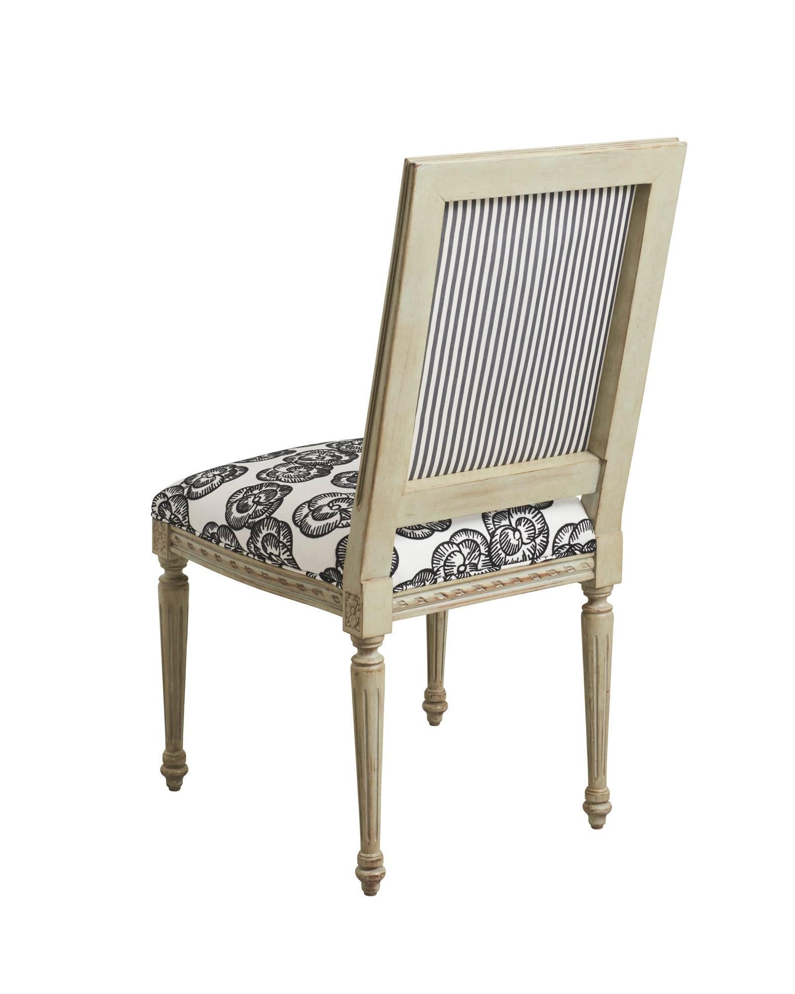 This pair of exquisite Schumacher French Louis XVI side chairs feature a classic frame, hand-carved from European Beechwood. They are upholstered with Schumacher x Vogue Living's Mona fabric in its Blackwork colorway. Derived from a 1920s fashion