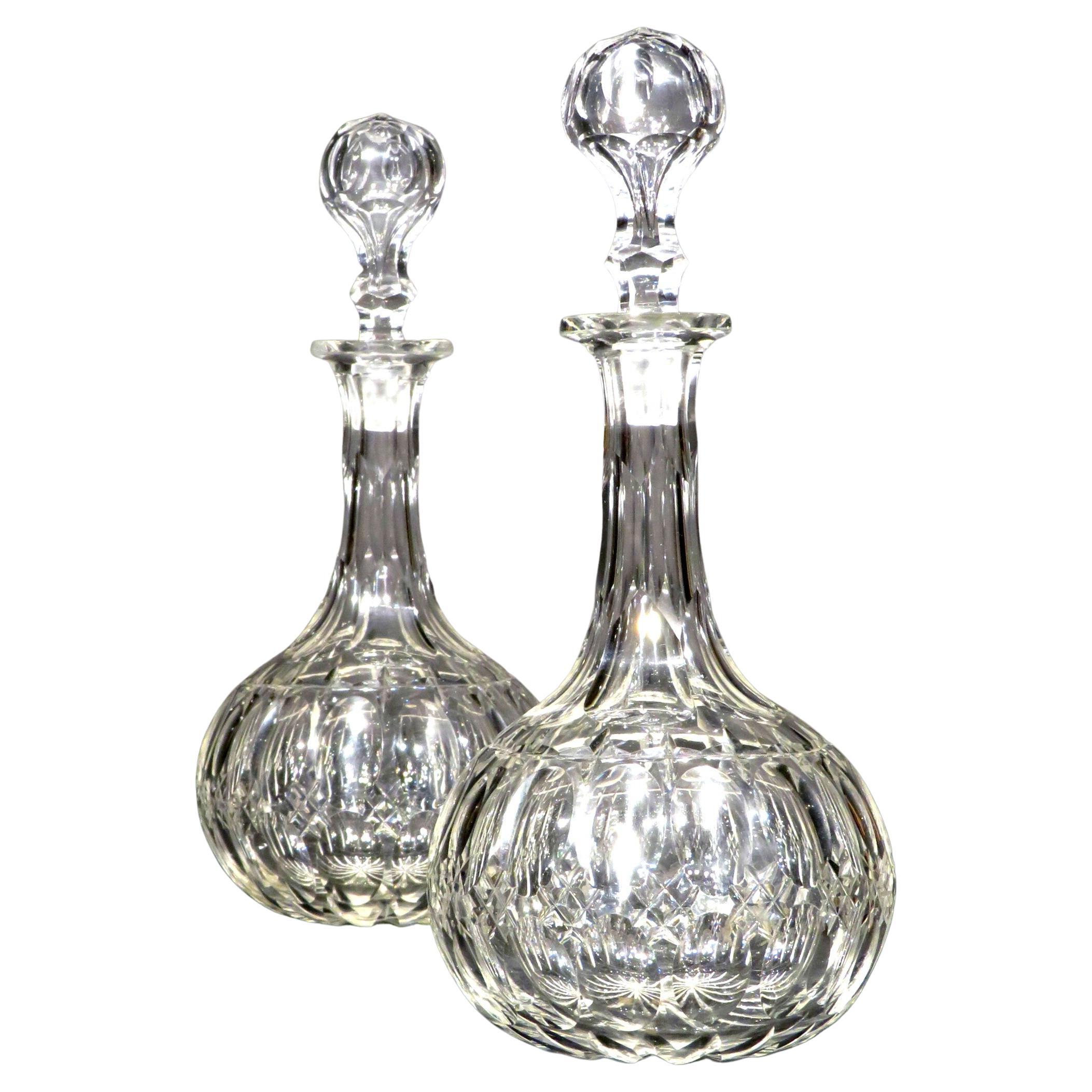 A very handsome matched pair of 19th century cut glass decanters, both showing necks with navette & scalloped vertical cut flutes, their bases decorated with alternating bands of star cut motifs & scalloped flutes, their undersides having incised
