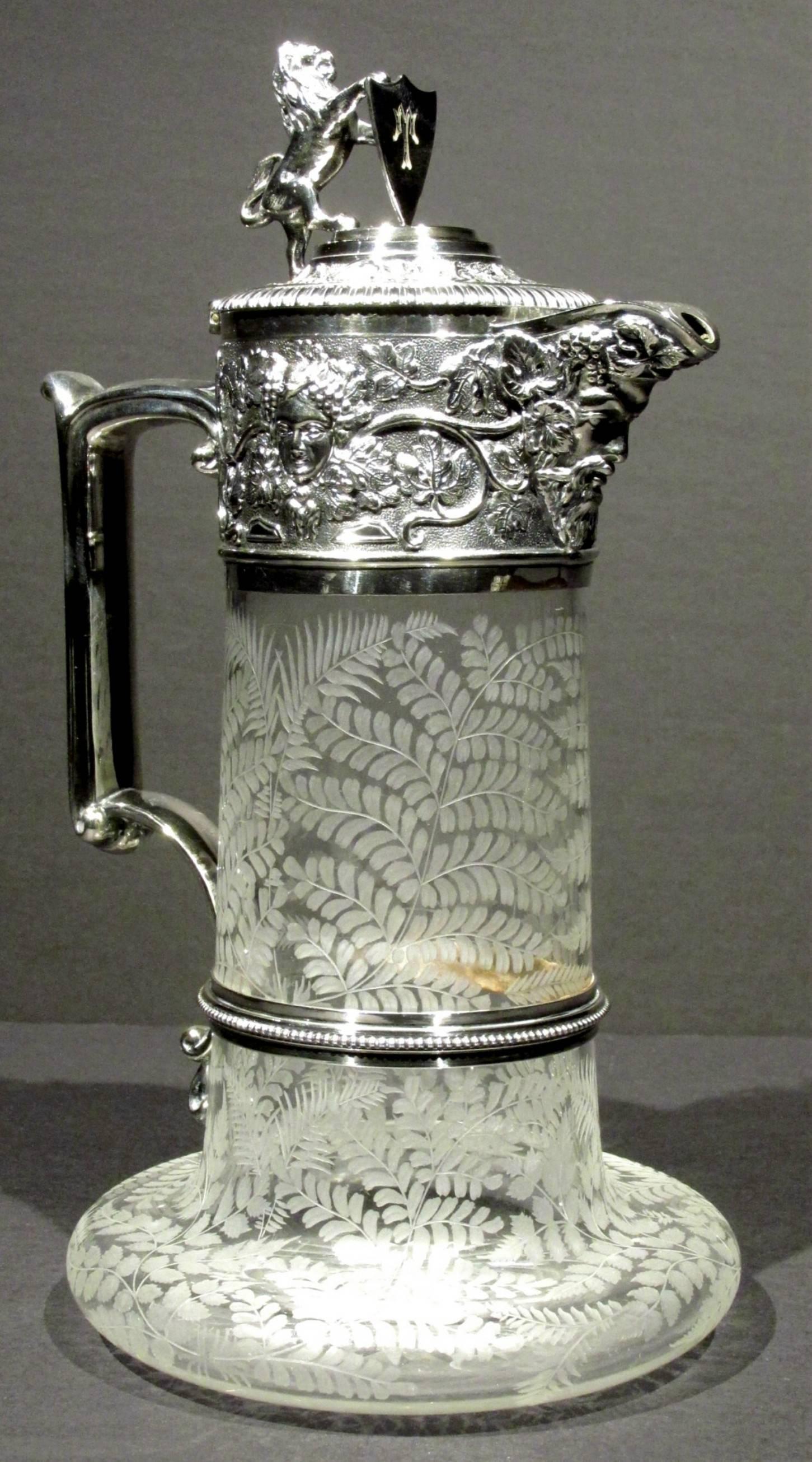 A superb example by the finest British silver plating specialists of the 19th century.
The glass body profusely etched with leafy motifs and vinery, rising from a flattened base to a cylindrical body fitted with a richly embossed collar bearing