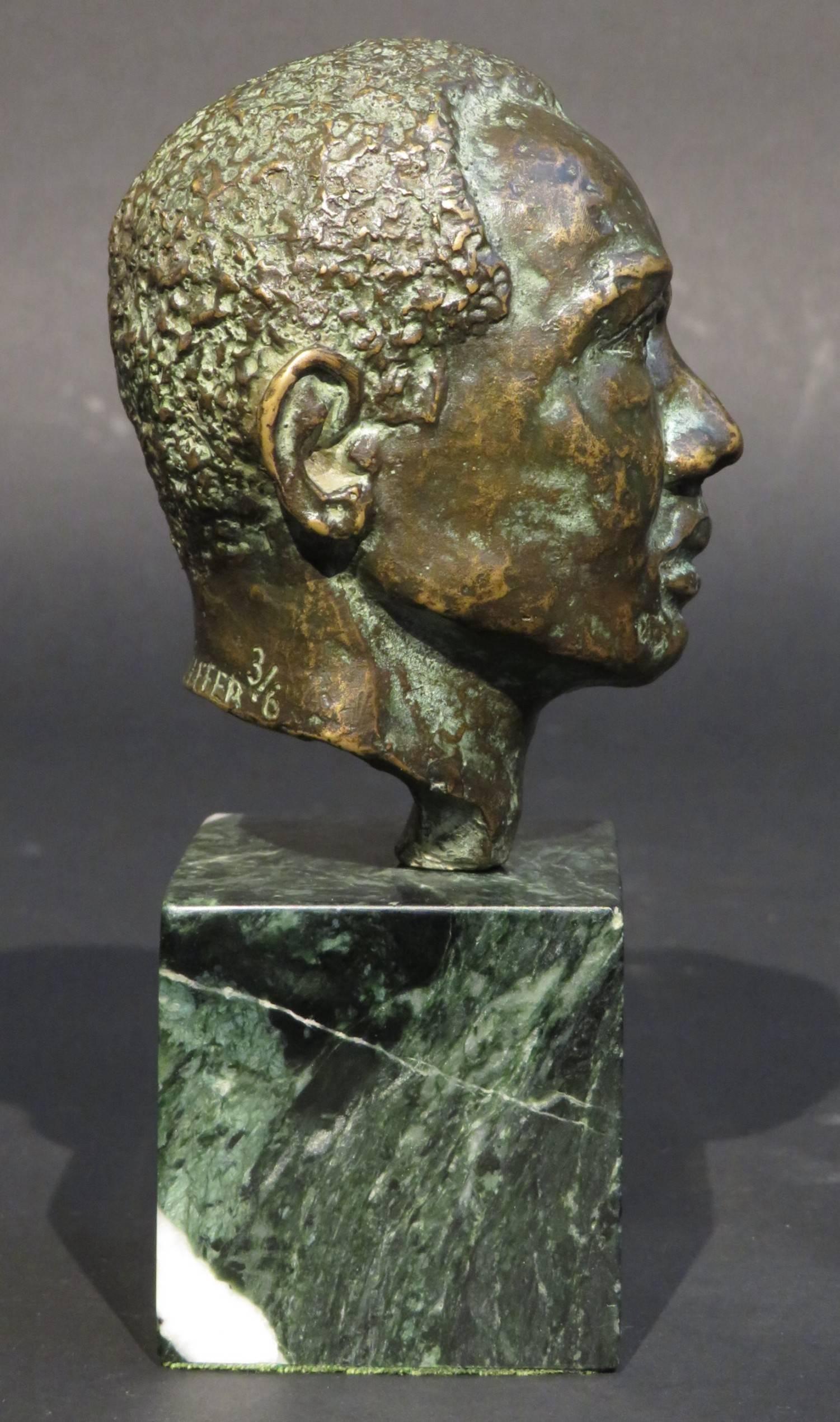 Busto de bronce en miniatura, finamente esculpido, de edición limitada, de un hombre de las Bahamas, con una fina pátina marrón/verde en su conjunto, firmado y numerado en el reverso H. Pfeiffer 3/6, y elevado sobre una base estriada de mármol