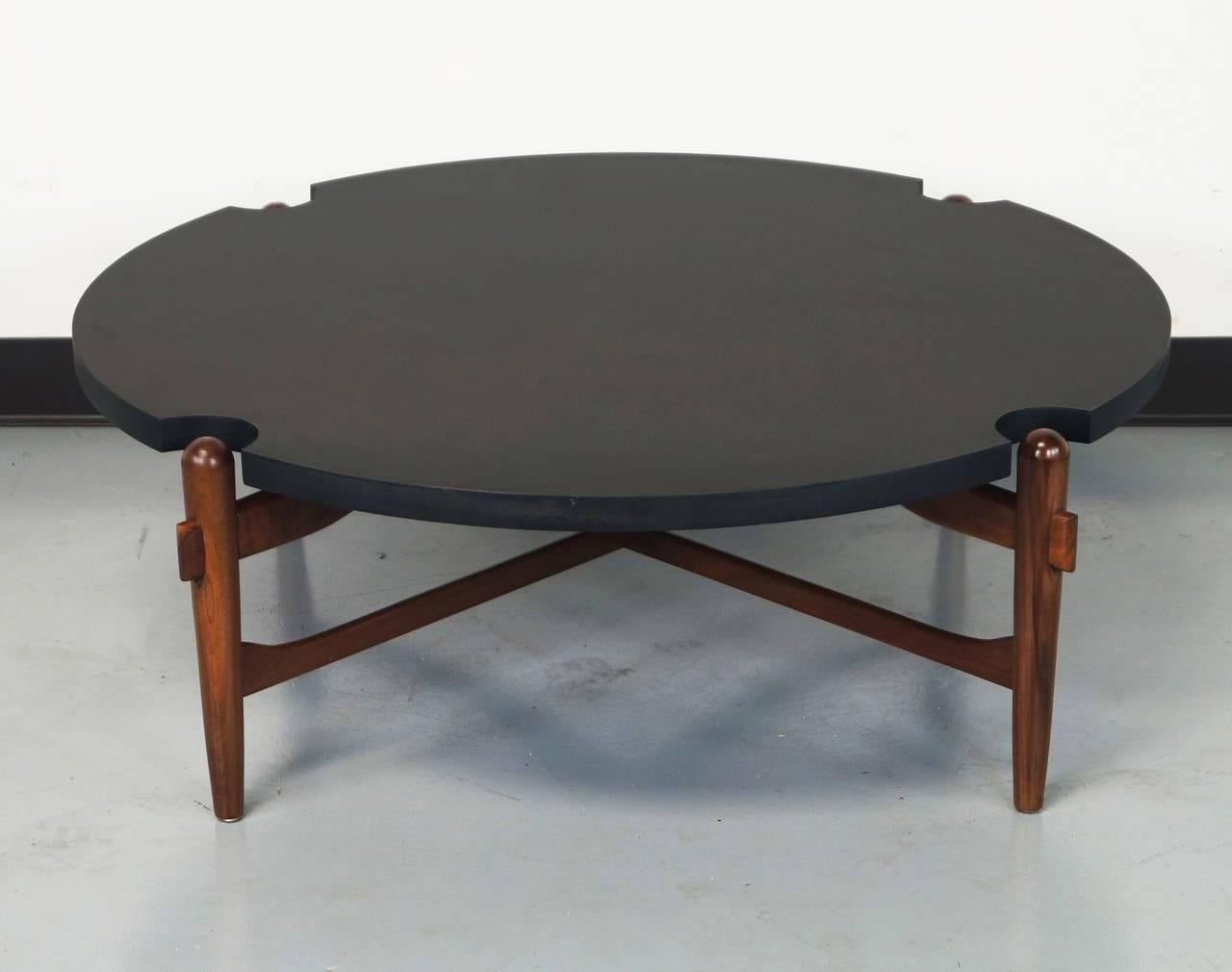 Vintage walnut coffee table features a round black laminate top with sculptural wood frame with cross-stretchers, original finish. This piece is attributed to Greta M. Grossman.