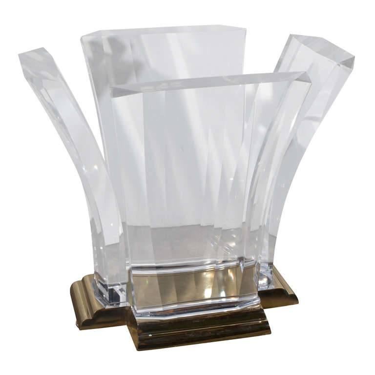 Sculptural Art Deco inspired table was introduced by Jeffrey Bigelow in 1976. Scrolled cast-bronze plateau anchors four gently arched, faceted cast-Lucite slabs. The table may be used as a centre table or dining table and the glass size can be