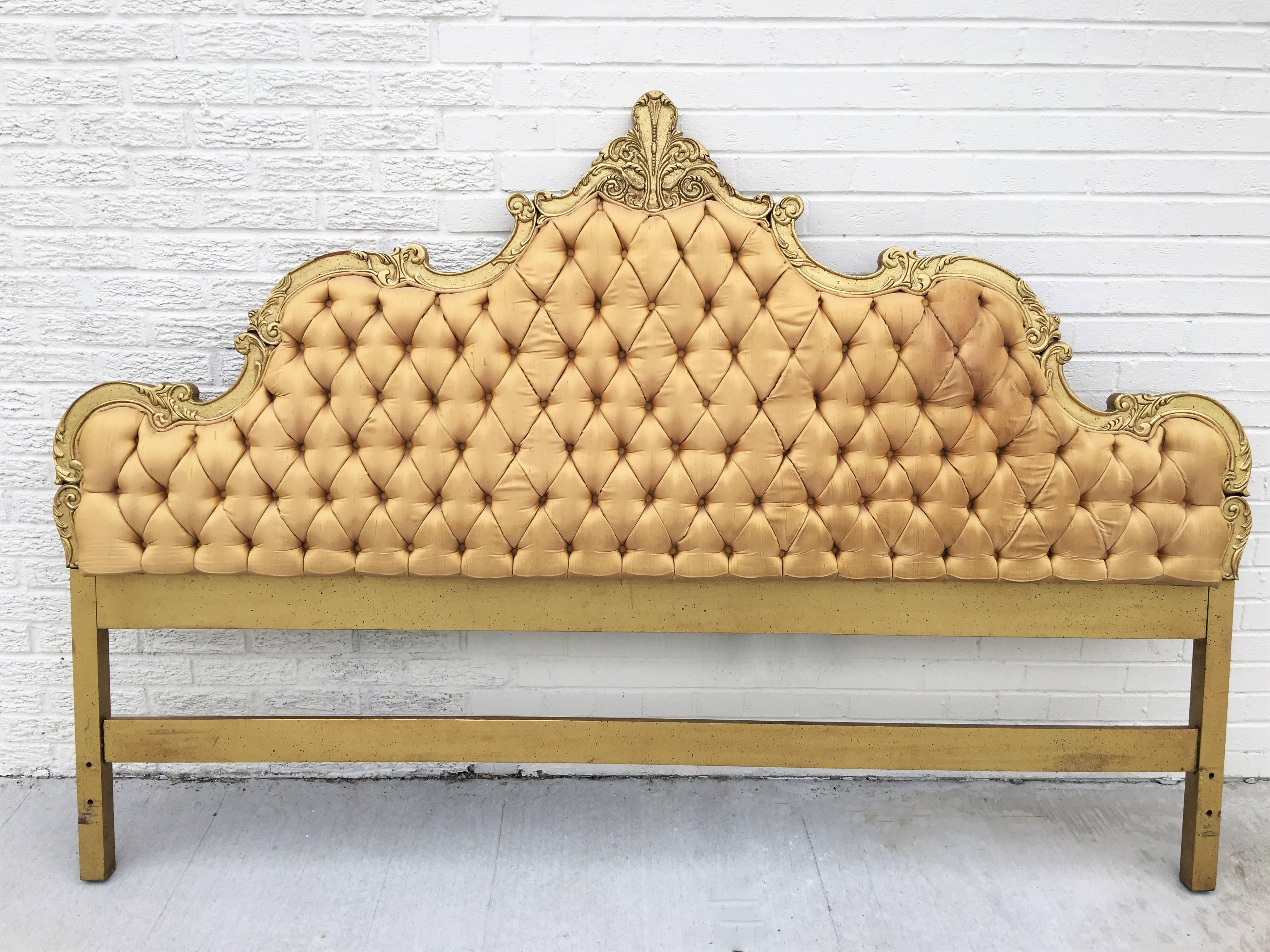Opulent Hollywood Regency style gold silk tufted king headboard. The headboard is ornate and curvy with a top plume. It’s in its original vintage condition. Upholstery is in good condition with minimal soiling. We offer the finest quality