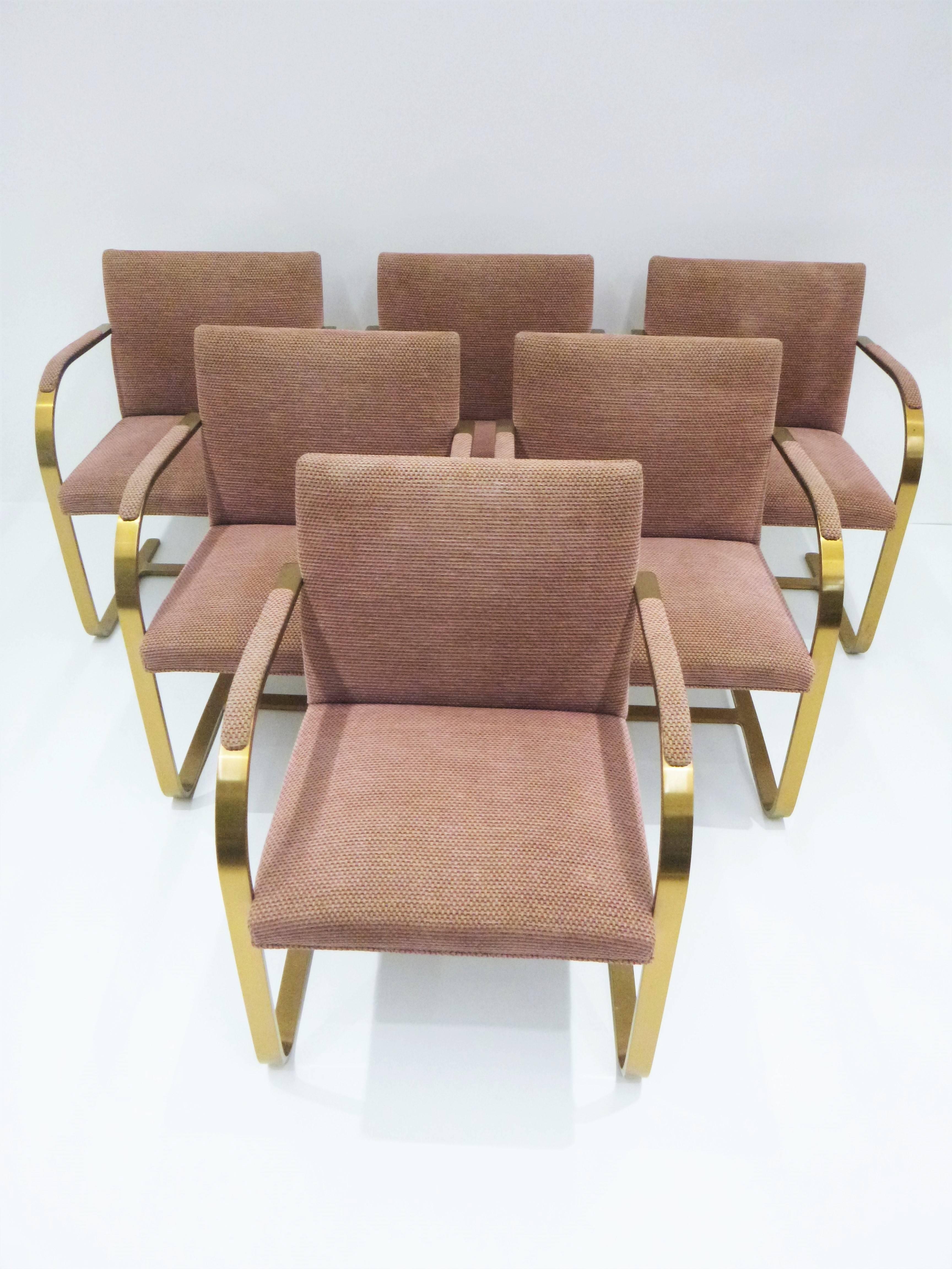Designed in the 1930s by Mies van der Rohe, the set of chairs were manufactured in the 1960s by the finest manufacturer Brueton. Solid brass, heavy flat bar construction. Upholstered over padded seats and backs with a padded armrest for comfort,