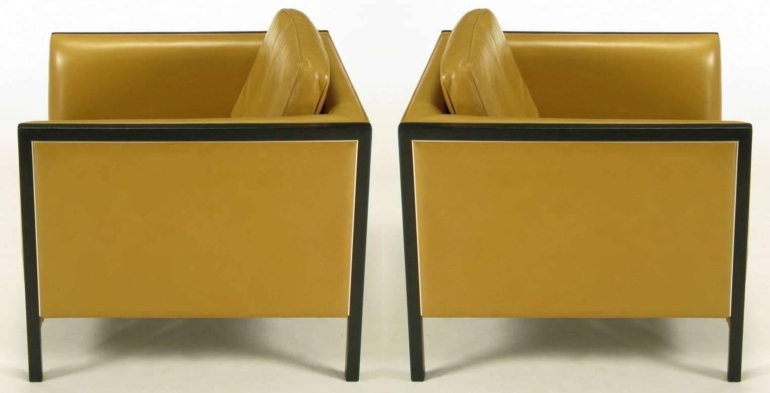 Pair of Stow Davis of Grand Rapids Michigan, even arm club chairs in camel leather with ebonized ashwood framing and aluminium inlaid detail. Loose seat and back cushions.