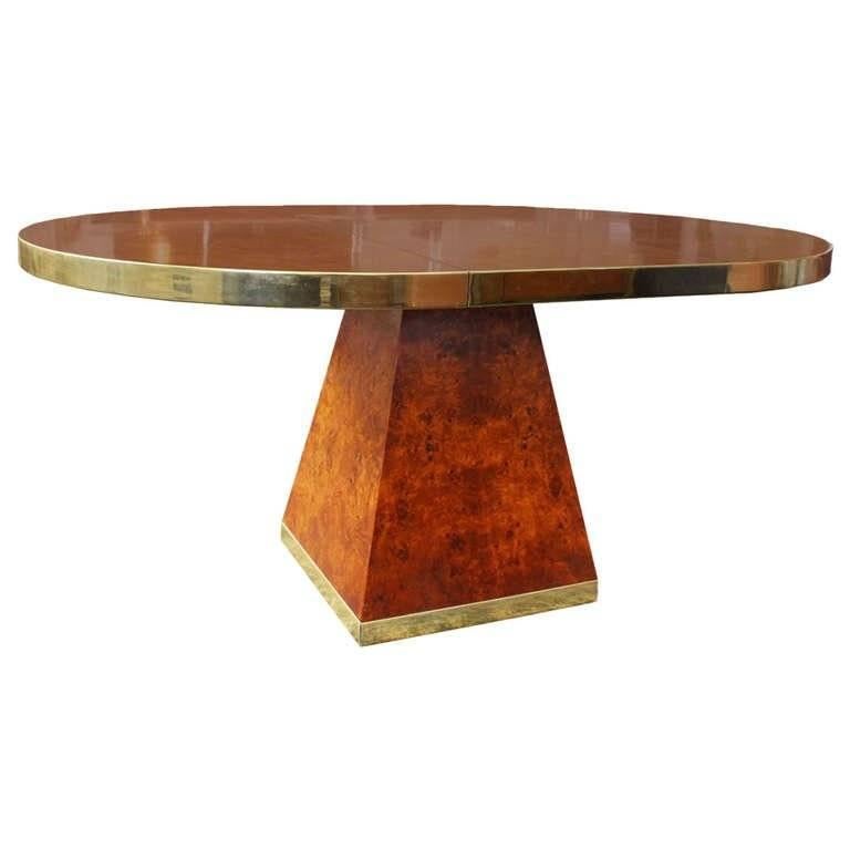 High-style, this is a stunning Pierre Cardin piece. Burl wood dining table with brass trim signed by Pierre Cardin. Includes one 18 inches wide drop in leaf. A single leaf expands the table from 45 inches round to 63 inches long.

Pierre Cardin is
