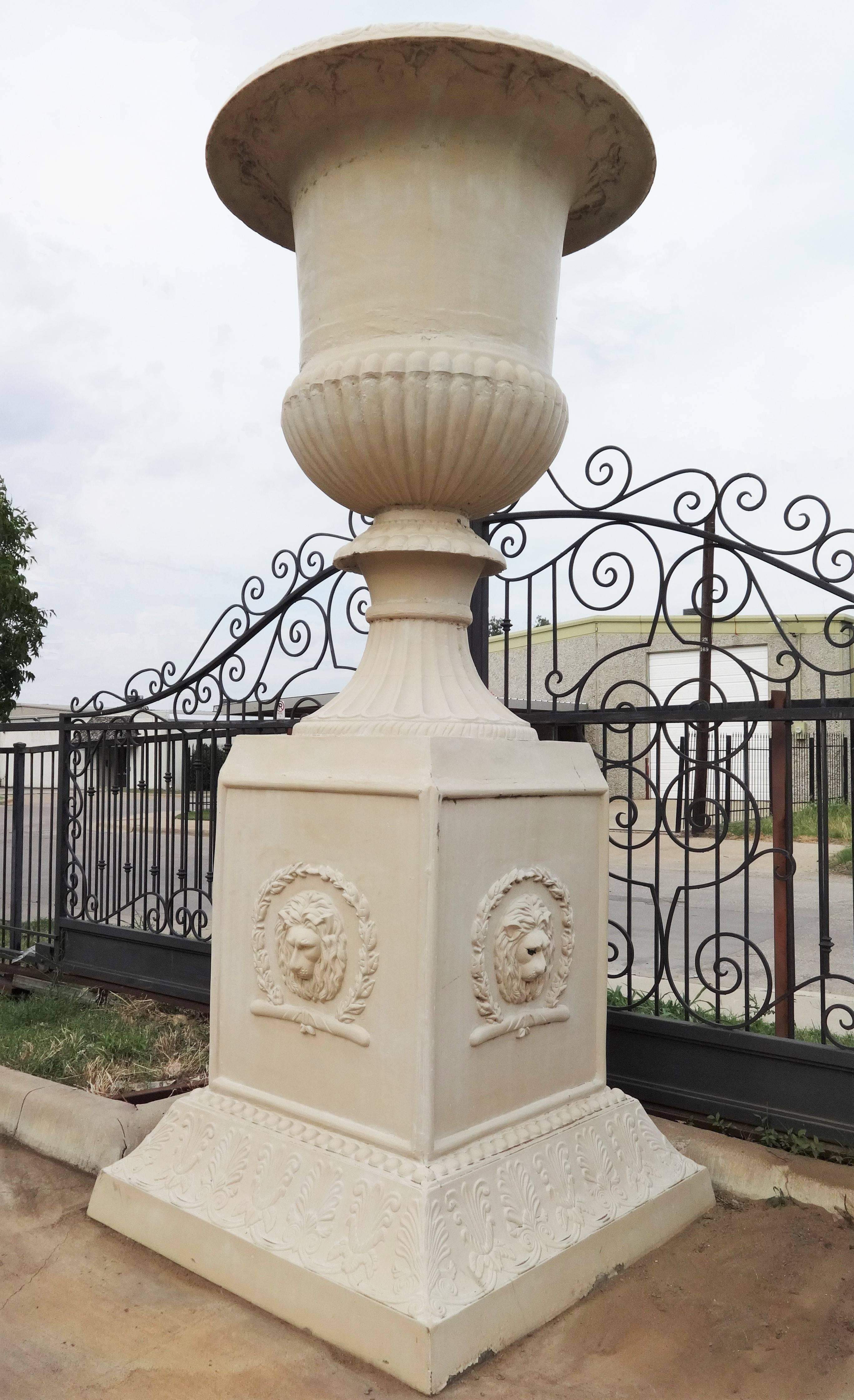 Truly magnificent, this Classic cast iron Campana urn with plain everted rims. Surmounted on a confirming cast iron plinth with decorative border and lion head wreathed panels. In perfect condition, with little weathering consistent with age. Very