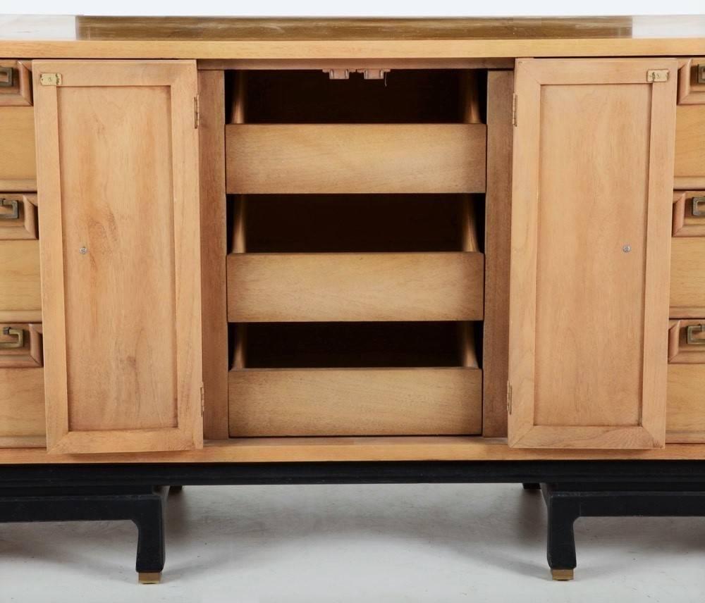 The dresser has columns of three drawers on each shoulder flanking two narrow doors in the centre, and a stepped apron with eight short feet. Each drawer has bevelled trim and dovetail joinery. Hardware includes brass tone pulls and knobs. Opening