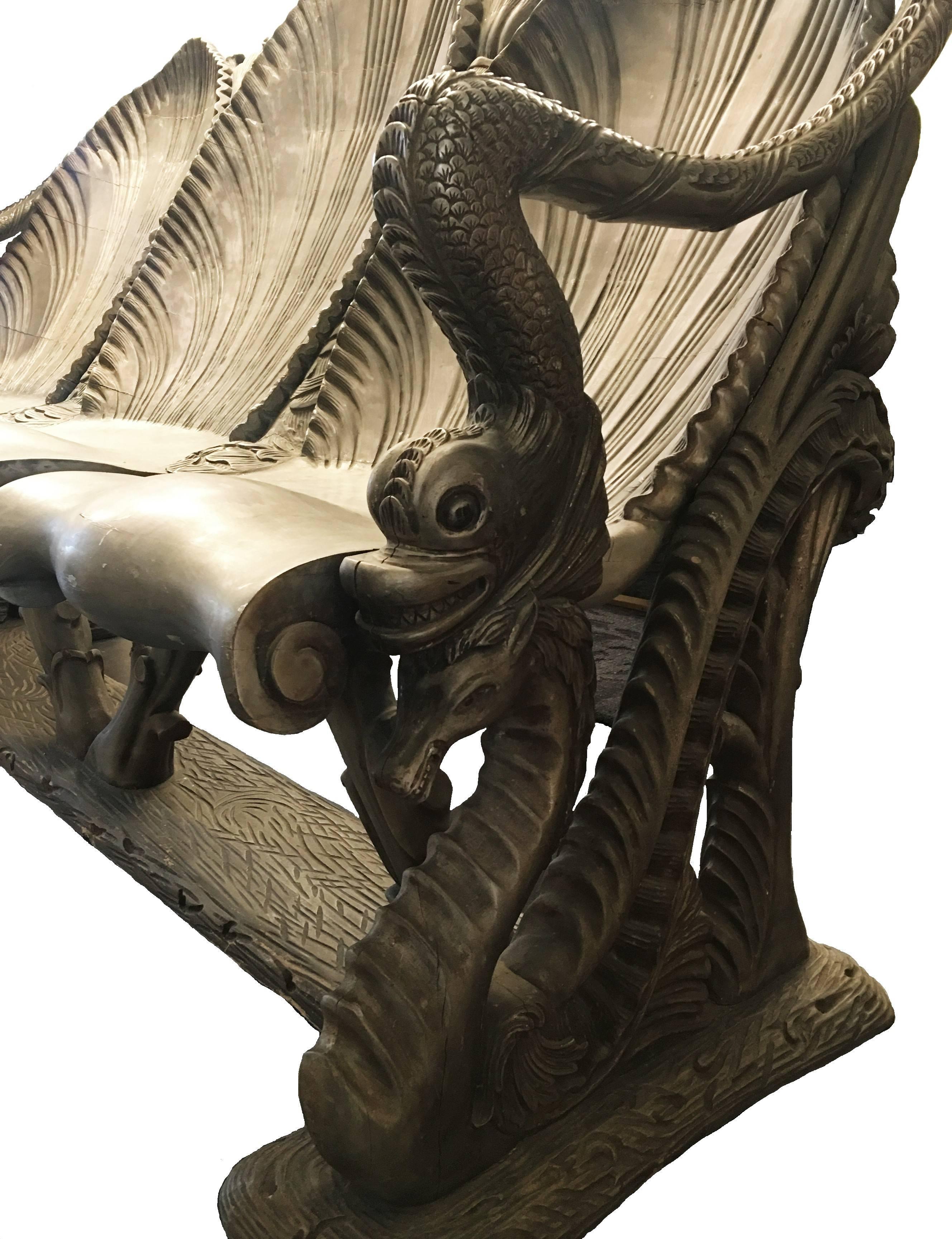 19th century hand-carved exuberantly shaped Venetian “Mecca” (gilt-varnished silvered) and green-gray painted settee exhibiting triple sea shell seat, armrests in the form of dolphins and the legs shaped in the form of seahorse motifs in various