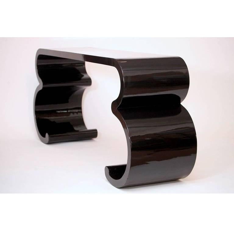 Sensational and dramatic console attributed to Karl Springer, lacquered in black. Outstanding piece with great presence and exceptional design. This can be professionally lacquered at an additional cost. Inquire for our in-house lacquering