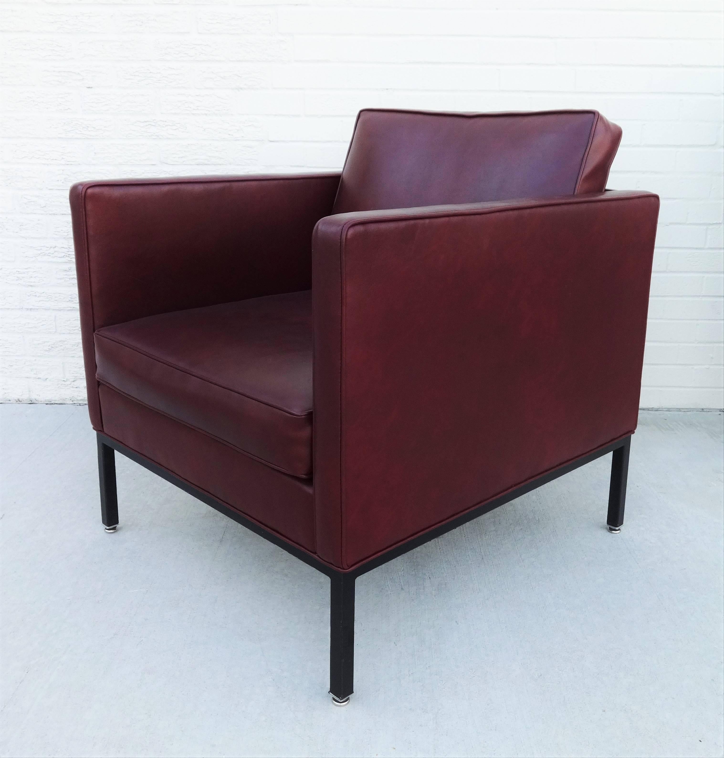 These Florence Knoll style club chairs maintain their original upholstery, standing on a black lacquered metal frame. Evidently reupholstered sometime in the 1980s, with a vinyl upholstery. Can be used as they are or reupholstered to match. Call us
