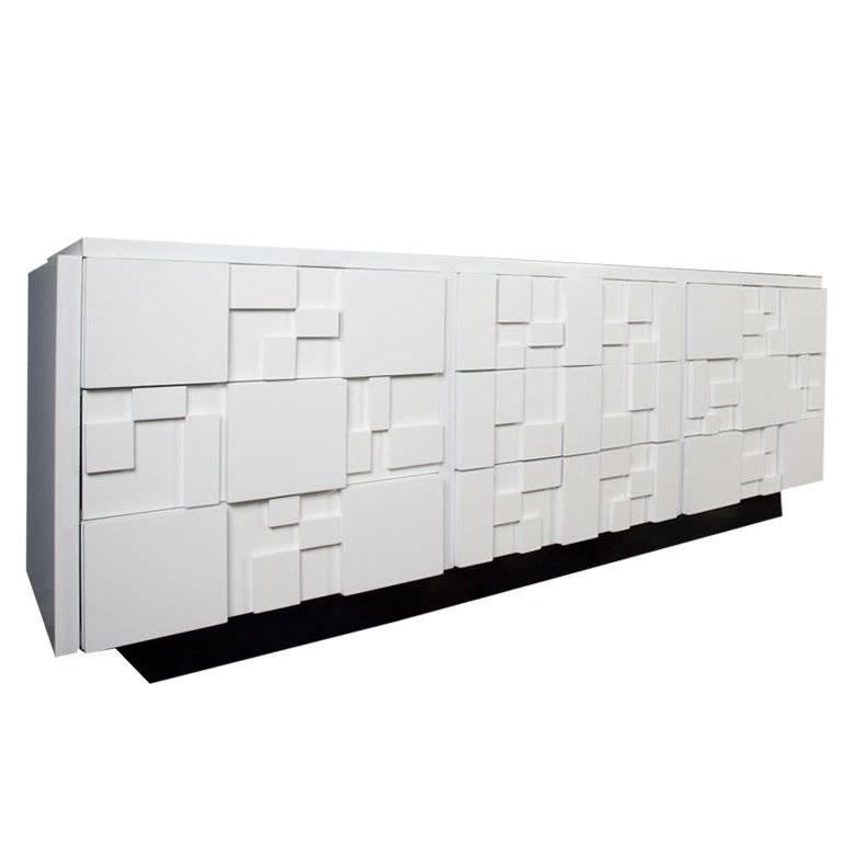 Newly lacquered in white with black base, this stunning nine-drawer dresser made by The Lane Furniture Company in the 1960s. The Brutalist Styling on the block fronts is a reference to the Paul Evans Cityscape line.

 