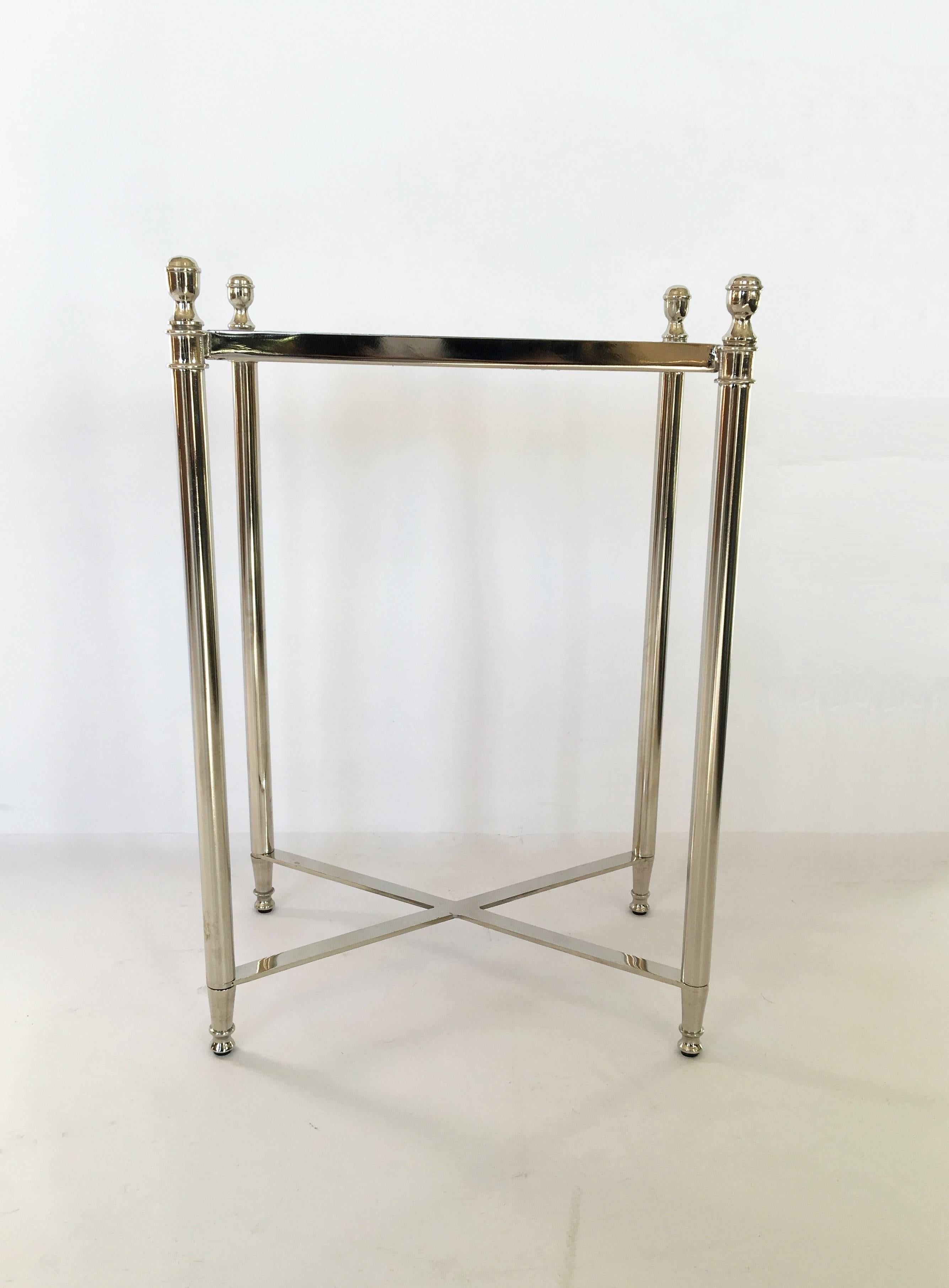 Small late 20th century side table, with white granite top on polished chrome frame and base, surmounted by finials, with crossed stretcher.