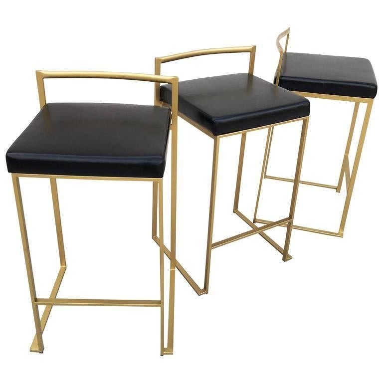 Minimalist bar stools in gold painted frame with black leather seats designed by Enzo Berti and produced by LaPalma, Italy, circa 1998. Six bar stools available. Sold in pairs.