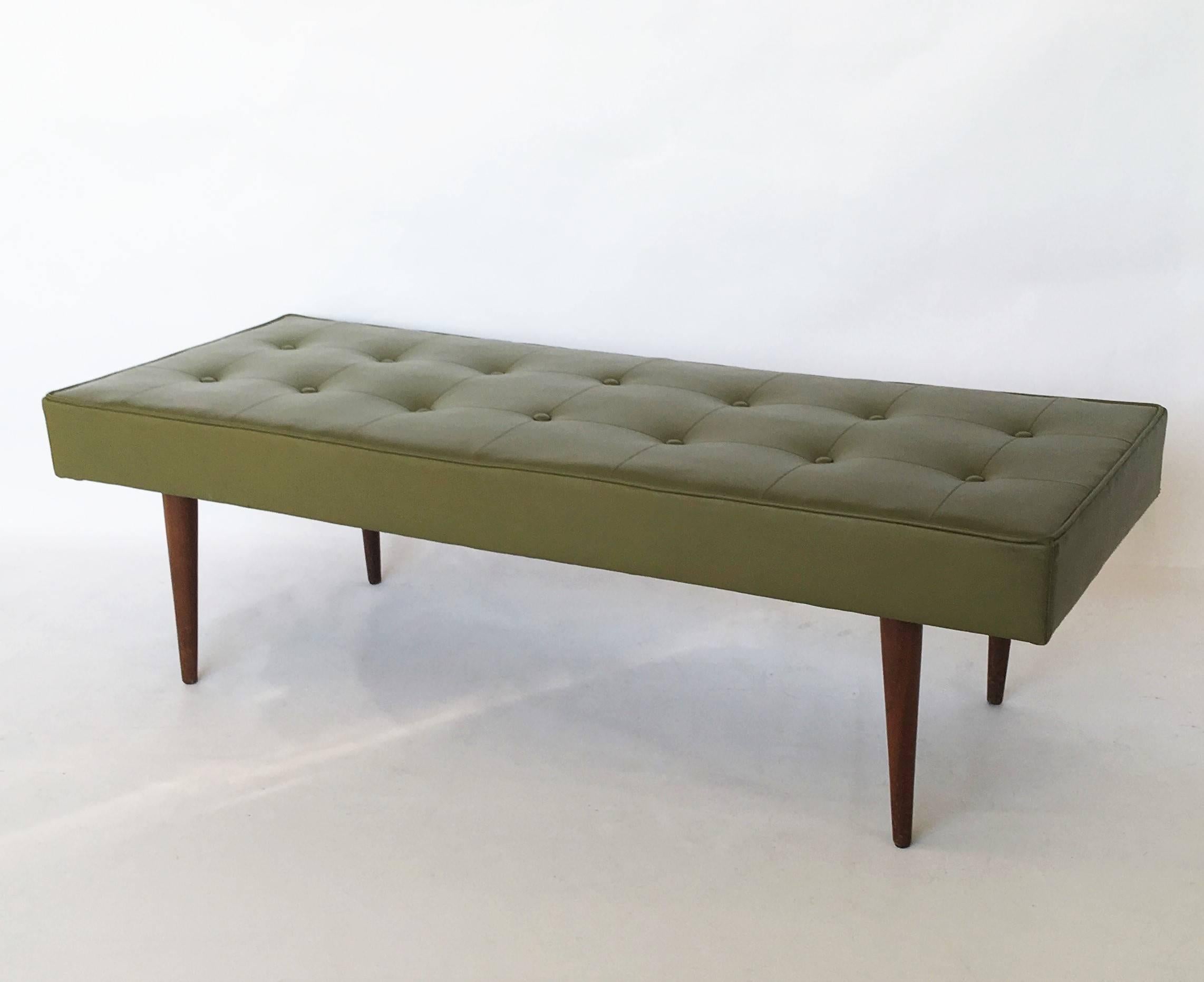 Simple and elegant Mid-Century Modern rectangular bench by Baughman for Thayer Coggin. Bench is upholstered in original green; tufting and piping add visual interest. Finished with tapered legs in dark walnut. In nice vintage condition.