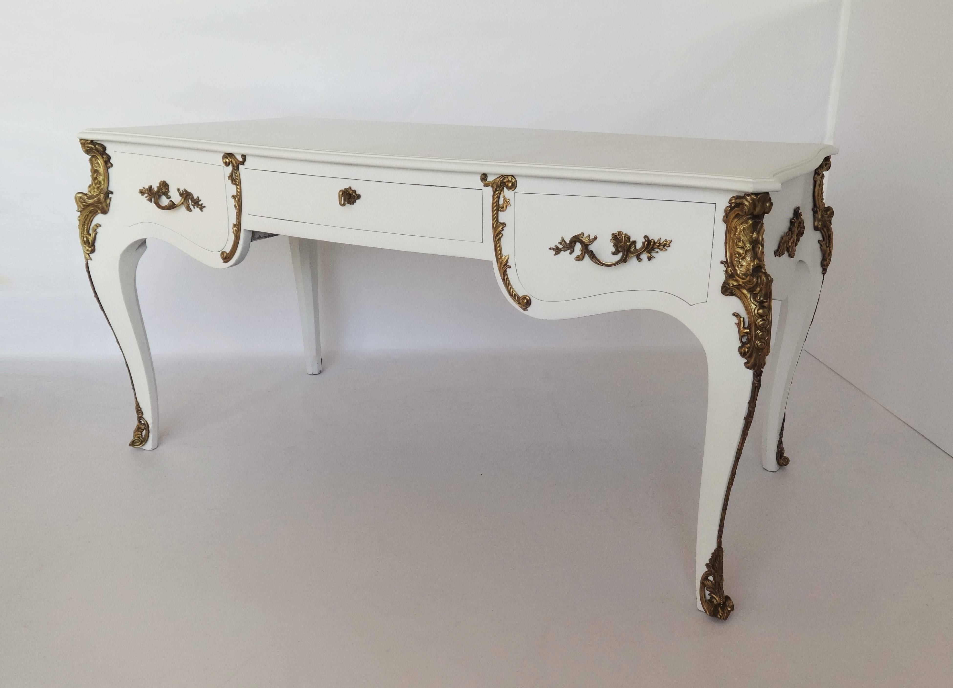 Fine, French produced Louis XV style bureau plat, gilt embossed with lacquered frame. With original key. Fine rocaille motif moulded mounts throughout, one side with three, deep space pull-out drawers, and the reverse with an identical facade to