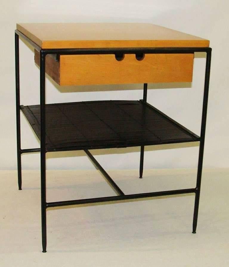 Wonderful design by Paul McCobb for Winchendon Furniture.
Blond maple top and drawers are refinished. Mounted on black painted metal frames with medial shelf of split-reed.