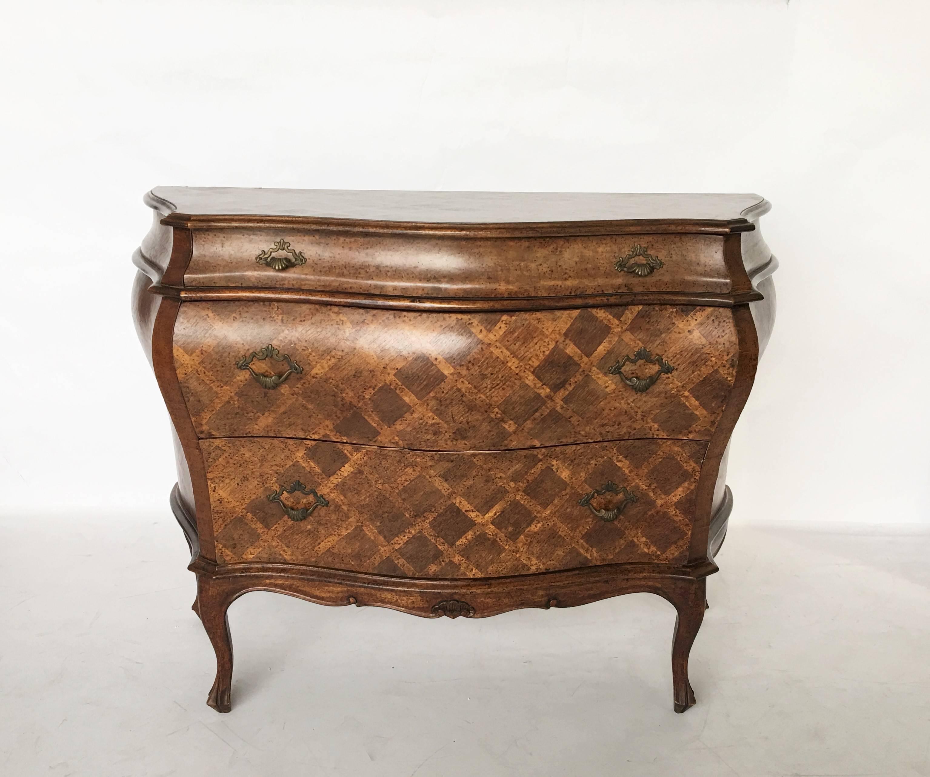 A Rococo style three-drawer Italian bombe commode or chest of drawers with inlaid cross hatch design, sitting on cabriole legs. Exhibiting a stellar patina and great lines.