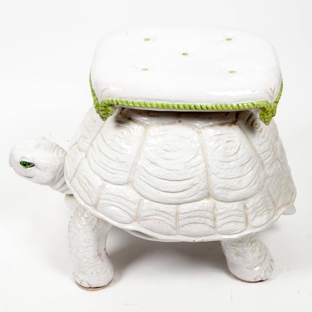 Pair of unusual form for a vintage garden seats in the shape of a turtle with tufted pillow top, all in cream ceramic with green details and green glass eyes. Makes a whimsical extra seat or glamorous drinks table.