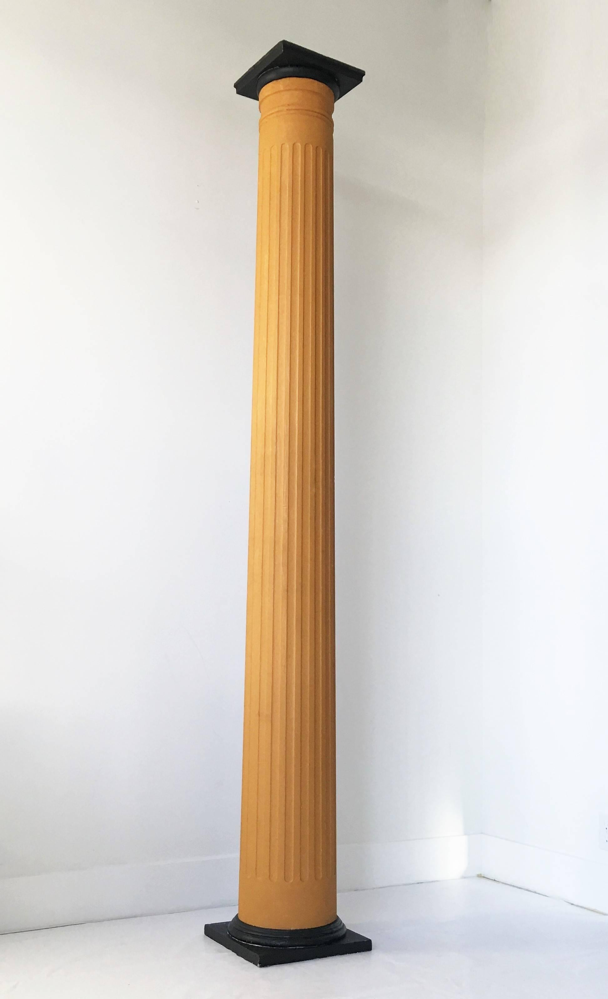 An impressive set of four architectural wood columns each in two parts, with square pedestal bases and fluted upper section.