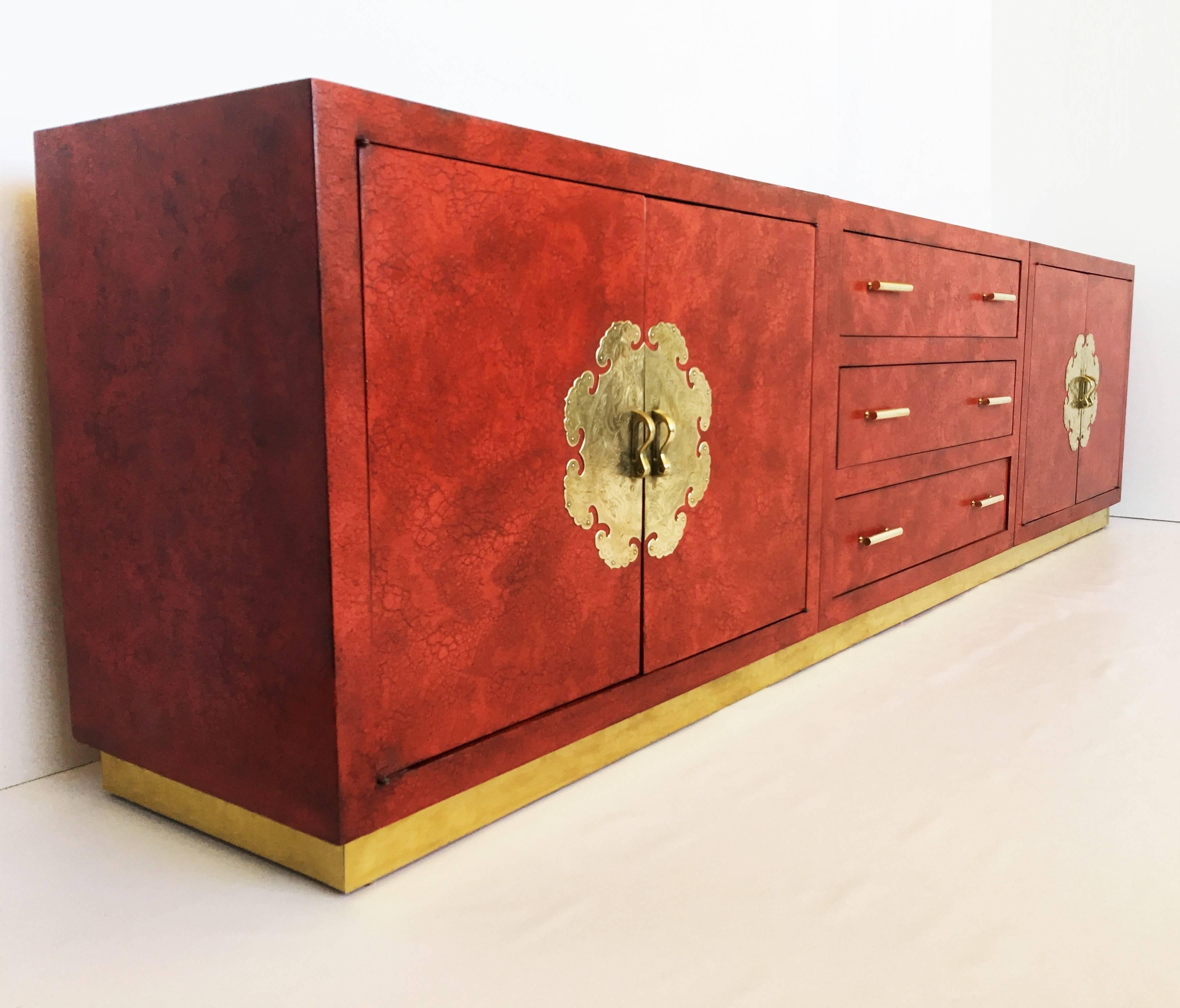 Exceptional sized clean, sleek channeling old Hollywood with a touch of the orient. Featuring crackle finish lacquer, four doors on either side and three drawers in the middle sitting on brass plinth with elaborate brass medallions plates and pulls.