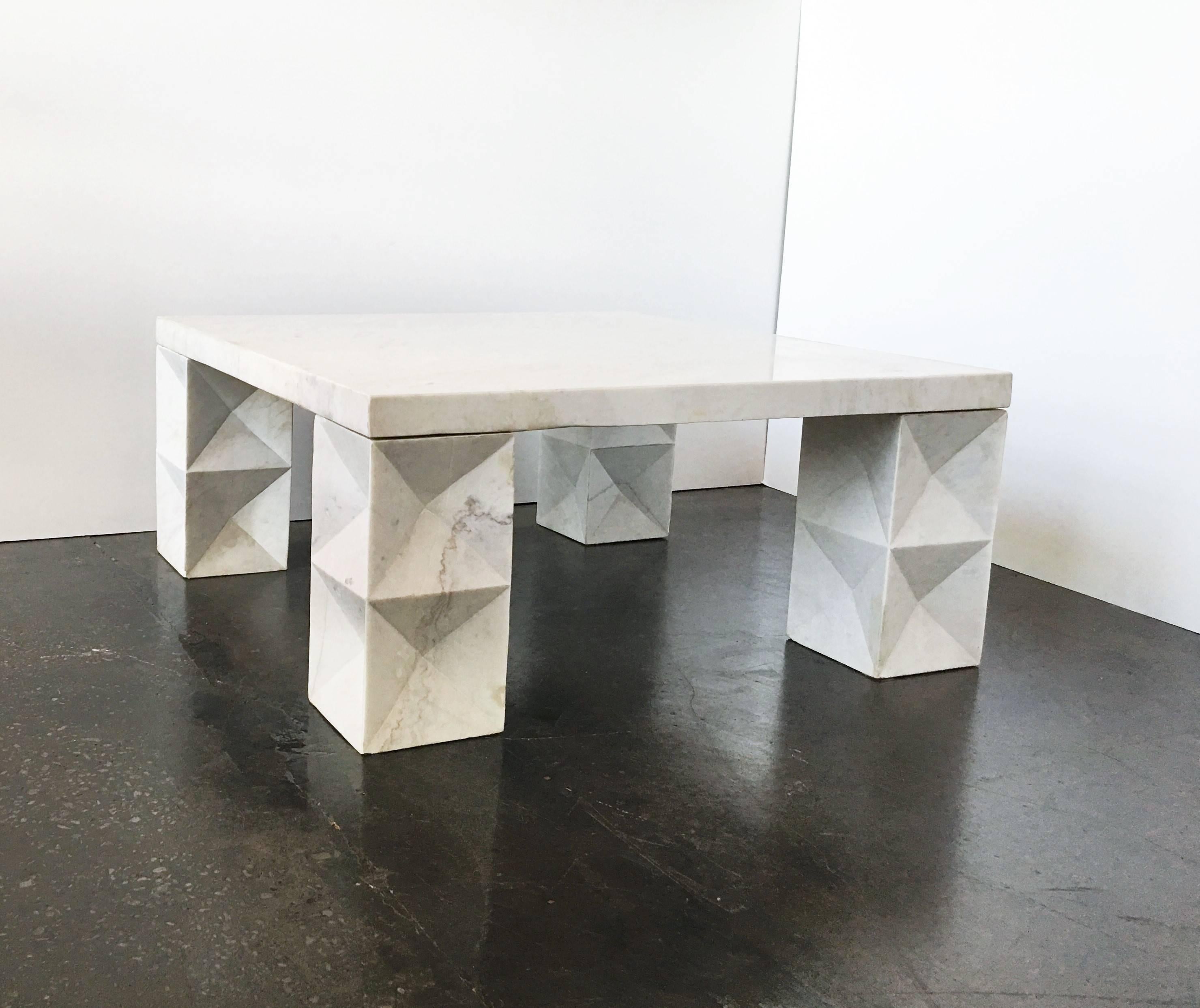 This architectural coffee table consists of four sculptural graphic designed block legs and a square top, all in beautiful Italian Carrara marble. The table is in wonderful condition and has been professionally polished. Can be used both indoor and
