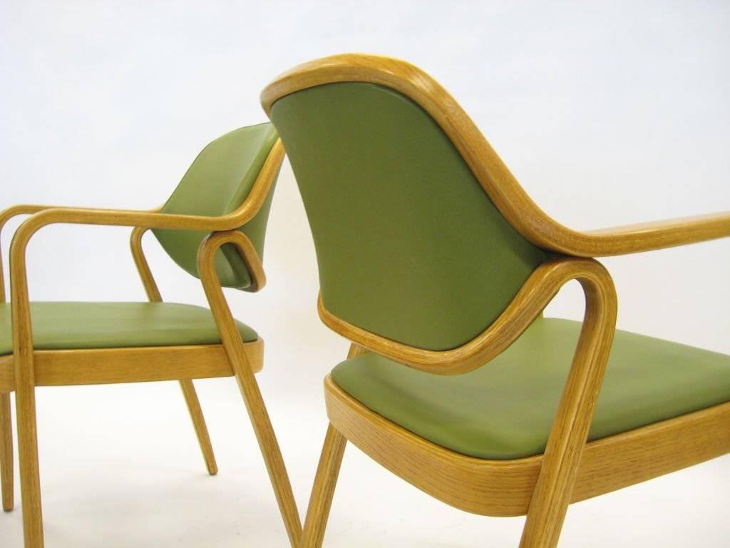 A vintage set of 16 Knoll model #1105 bentwood chairs designed by Don Pettit in 1965. The arms, legs, and back are formed from two sculpted pieces of bent oak in a rich walnut finish. Completely restored and reupholstered in apple green leatherette