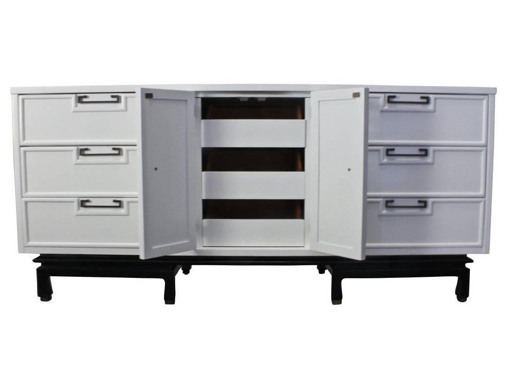 Stunning dresser by American of Martinsville finished in a white with a black  lacquered base. The handles are made of solid brass. The dresser has three 9 drawers, 6 out and 3 concealed. The dresser is solidly built and with great architectural