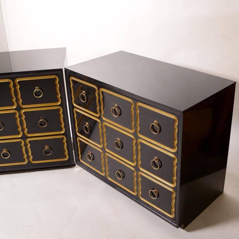 Pair of Dorothy Draper Espana chests / dressers with new black lacquer finish. Large brass ring pulls adorn the centers of the nine wavy gold rimmed drawers.