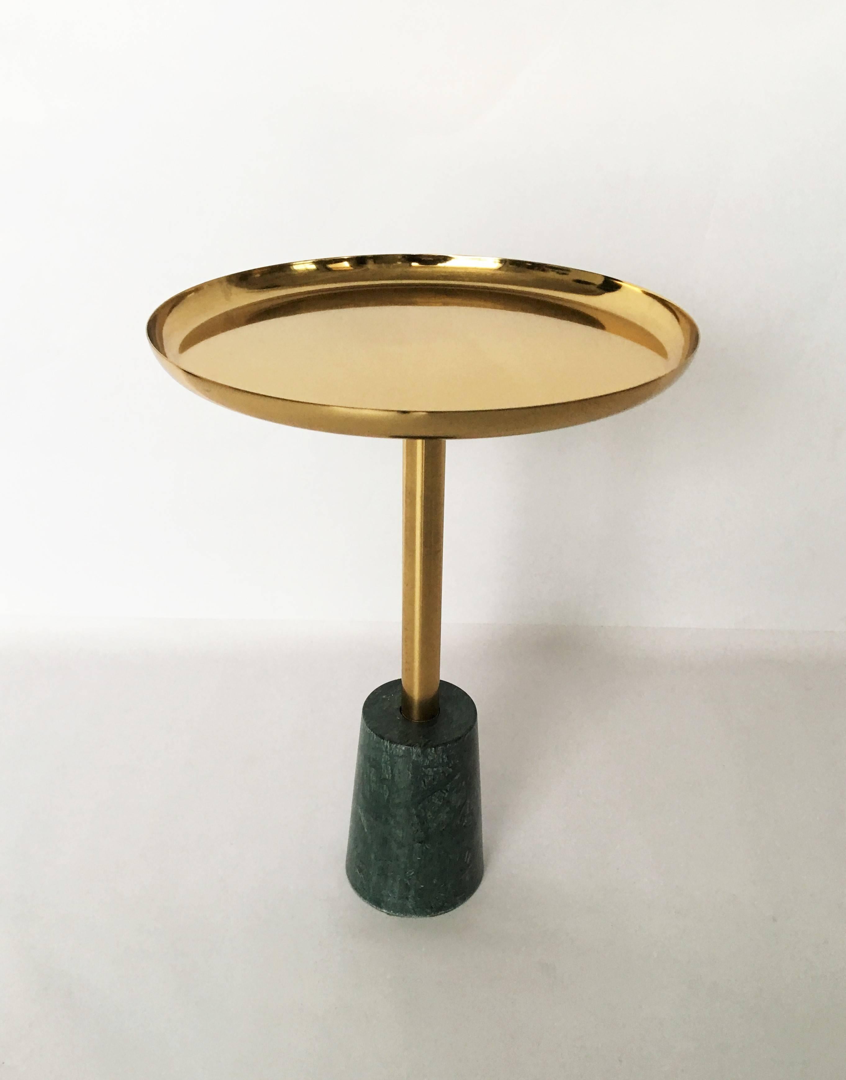 A stunning pair of side tables featuring sculptural green marble base provides stunning contrast to the brass top of this petite drink table, making it as much a minimalist work of art as it is a functional piece of furniture.