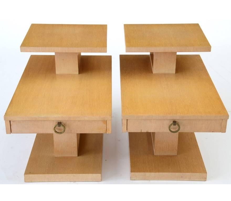 A pair of Modern end tables by Lane, in hardwood with a blonde finish. Each has a three-tier design, with a single drawer to the middle tier, having a hanging brass pull and dovetail joints, and a green felted interior. Marked to the undersides.