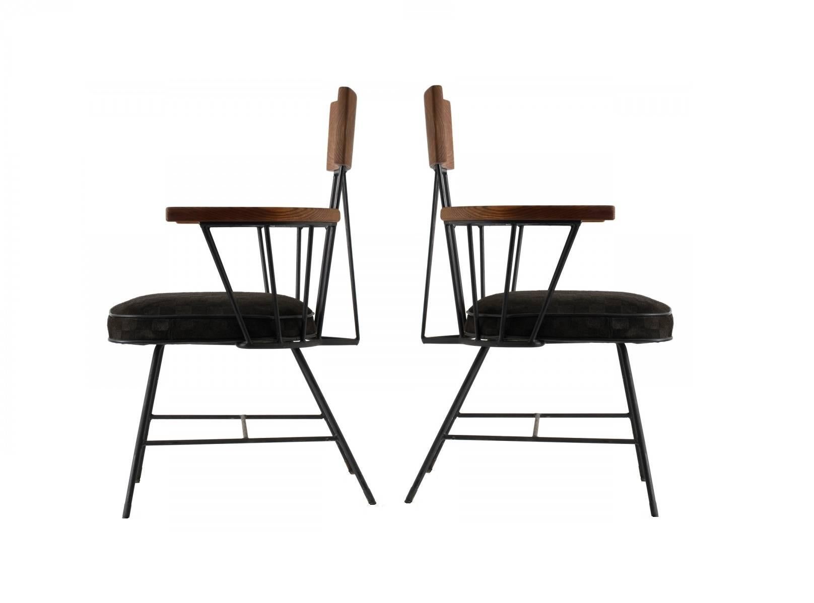 A unique set of ten dining chairs by Selrite. The black painted iron against the smooth grain of the wood perfectly embodies the Industrial feel of the era. Consists of eight arm and two armless chairs. The armchairs feature curved wood arms and