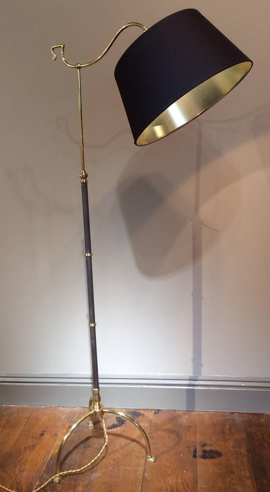 A stunning Maison Jansen brushed metal and brass adjustable reading lamp. Bowed legs with claw feet detail. The brushed metal column leading to a 360 degree rotating bulb. An adjustable column that is 58 inches at its highest and 49.5 inches at its