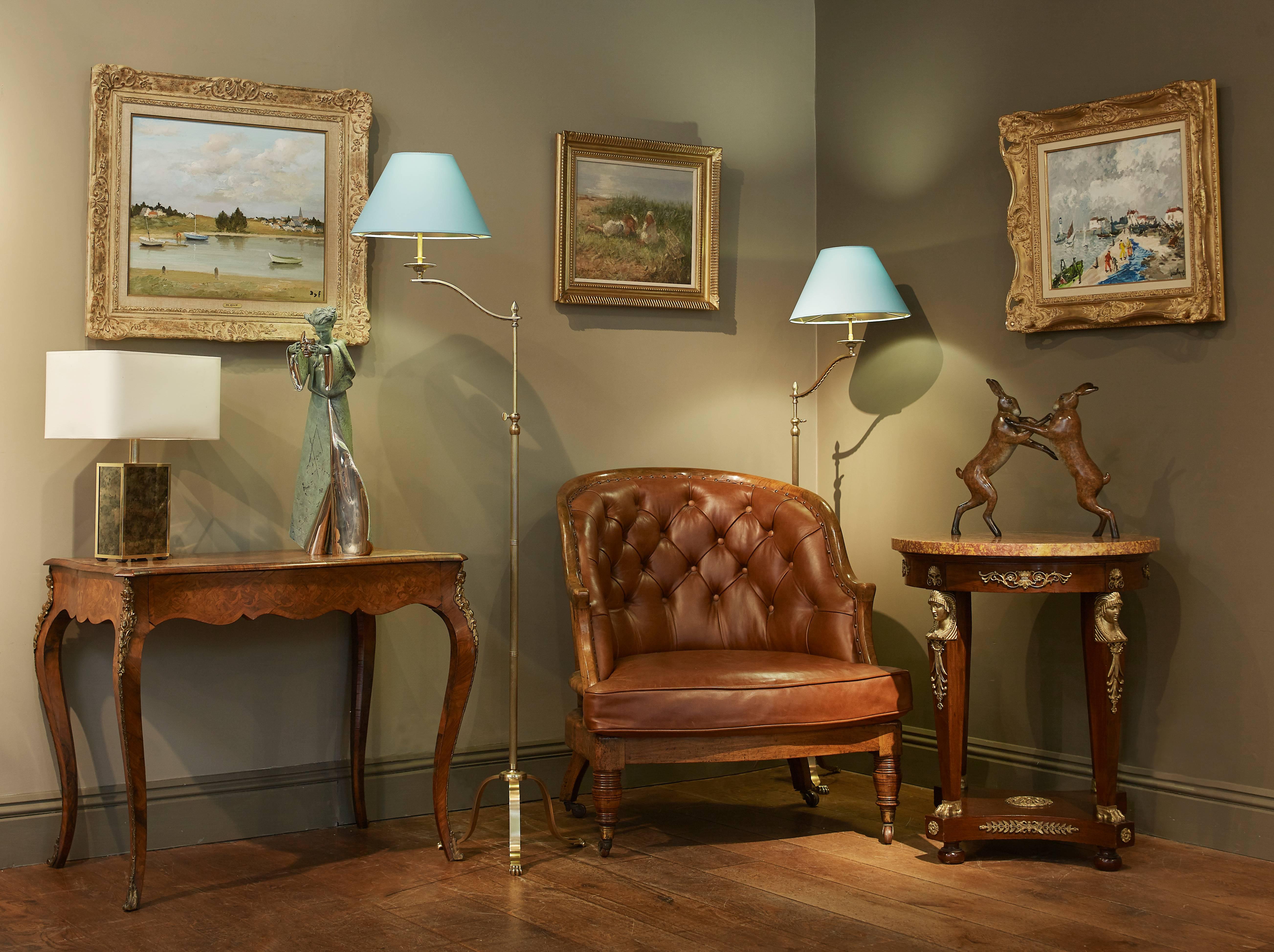 A rare pair of Maison Jansen adjustable floor lamps. Both with lovely detailed claw feet on the base. A heavy fluted brass column leading to an adjustable, rotating bulb. The lamp measures 62 inches at their highest and 55 inches and their lowest.