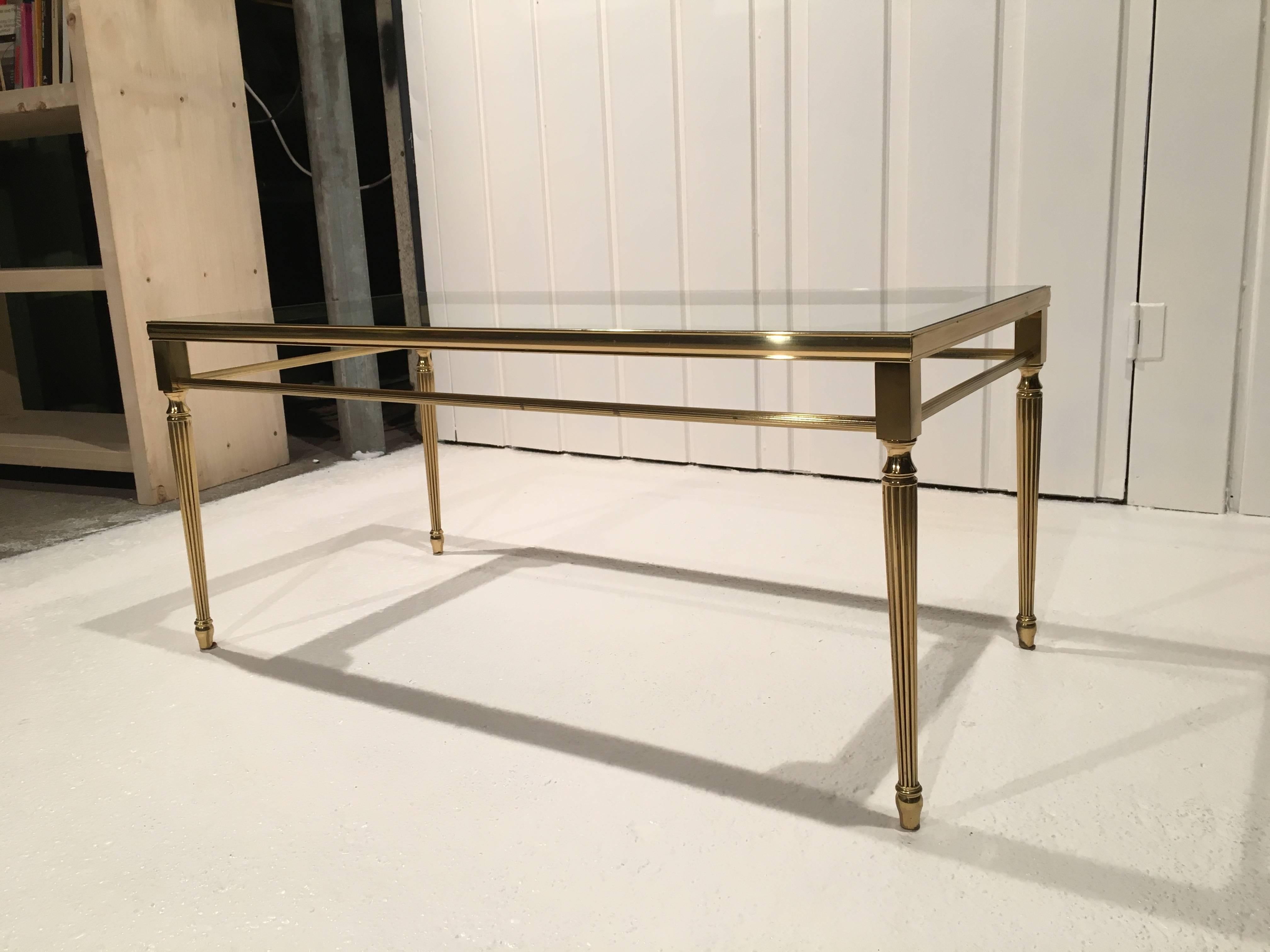 Antique coffee table in brass with glass top. Beautiful geometric details like feet and mirror in glass. Good condition, some stains from patina.